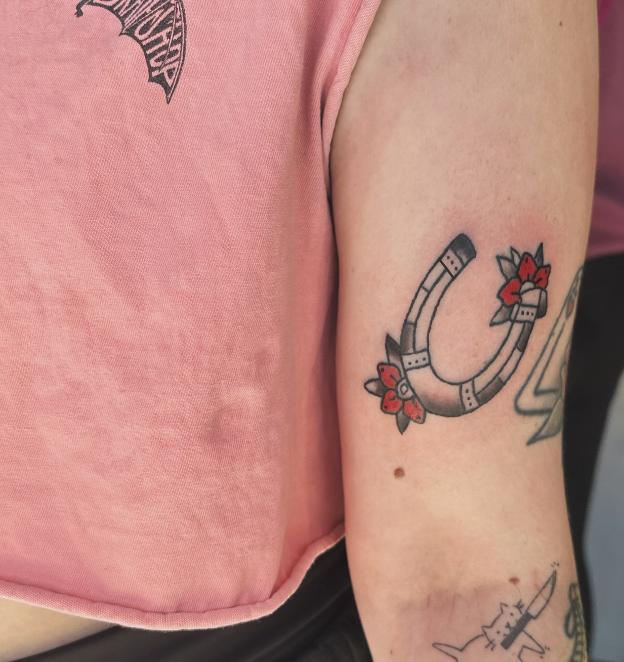 Horseshoe with flowers American traditional tattoo on the forearm by Madeline Seeley