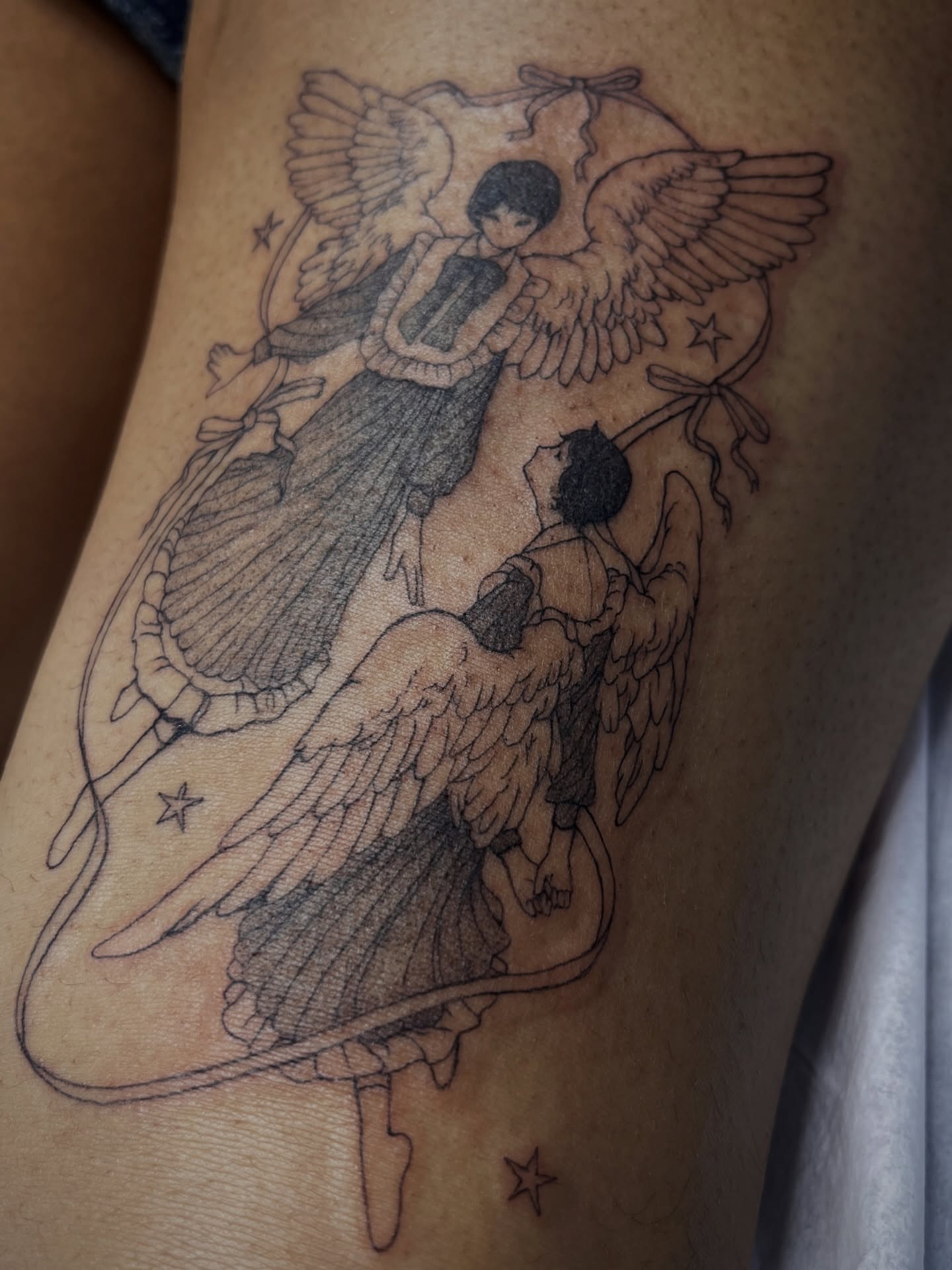Angelic figures black and grey tattoo on the thigh by Sarah Jurgielewicz