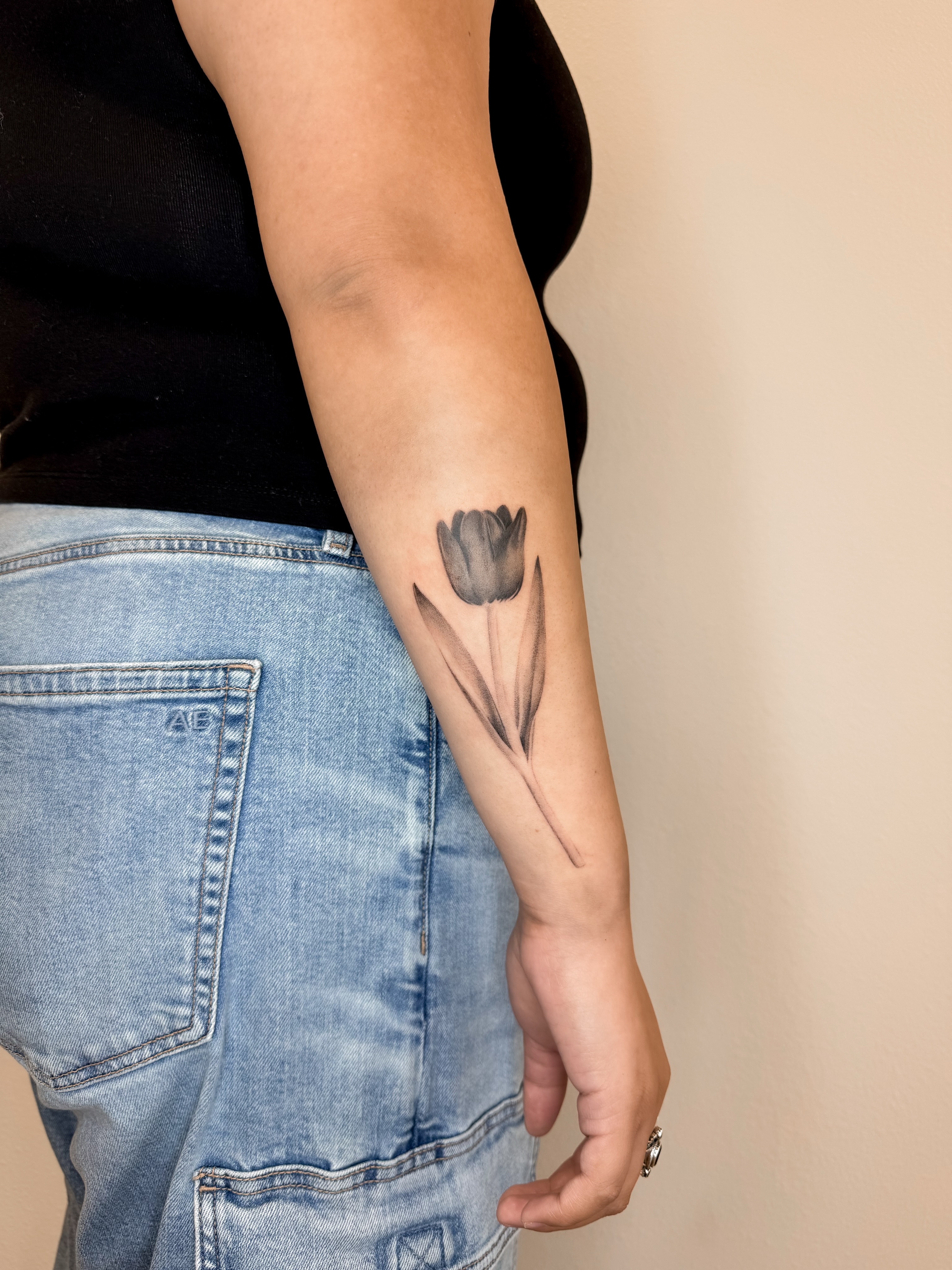 Tulip black and grey tattoo on the forearm by Rylee