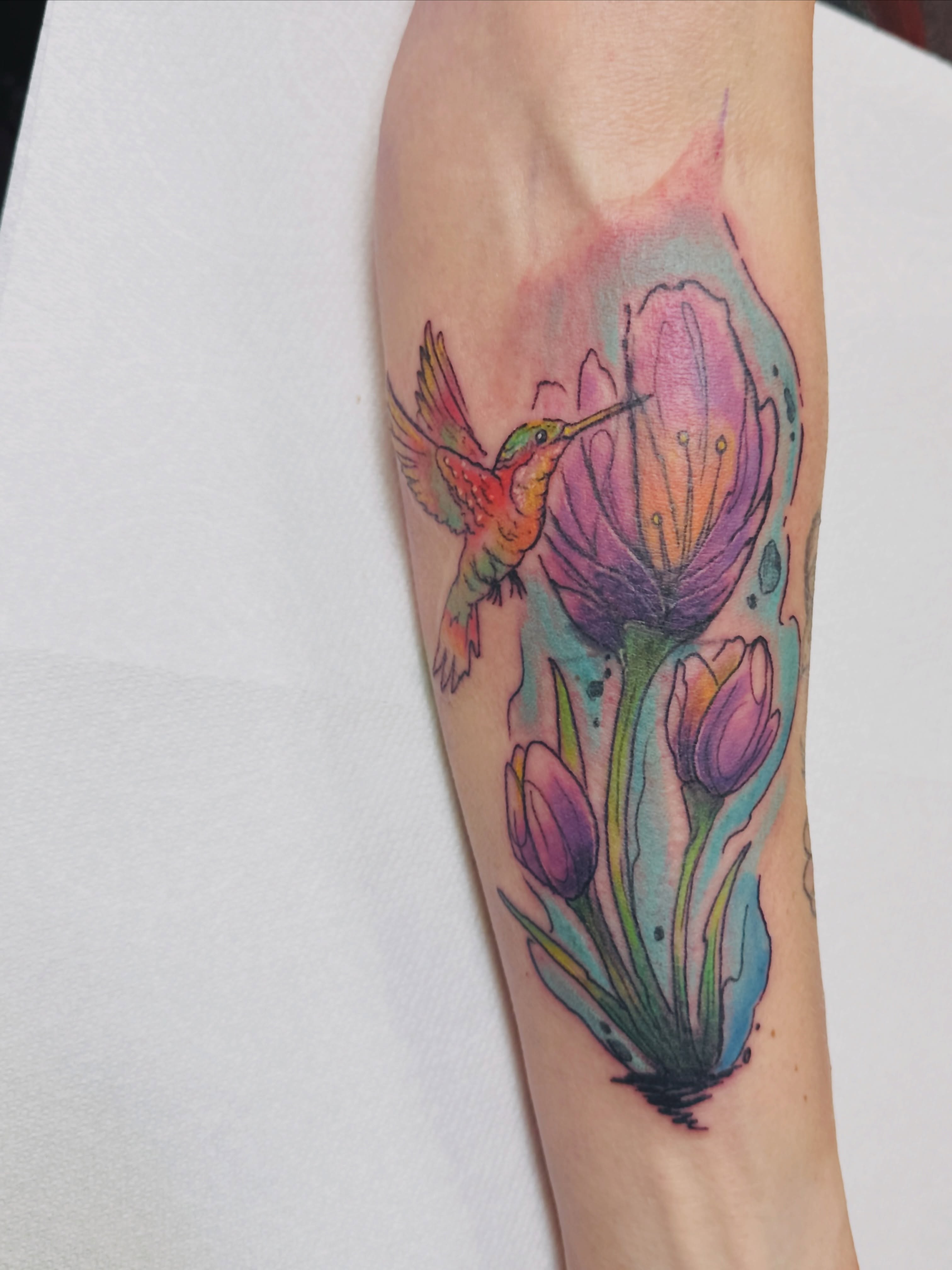 Hummingbird and tulips watercolor tattoo on the forearm by Will McCoy (Tattooist), Murray, Utah