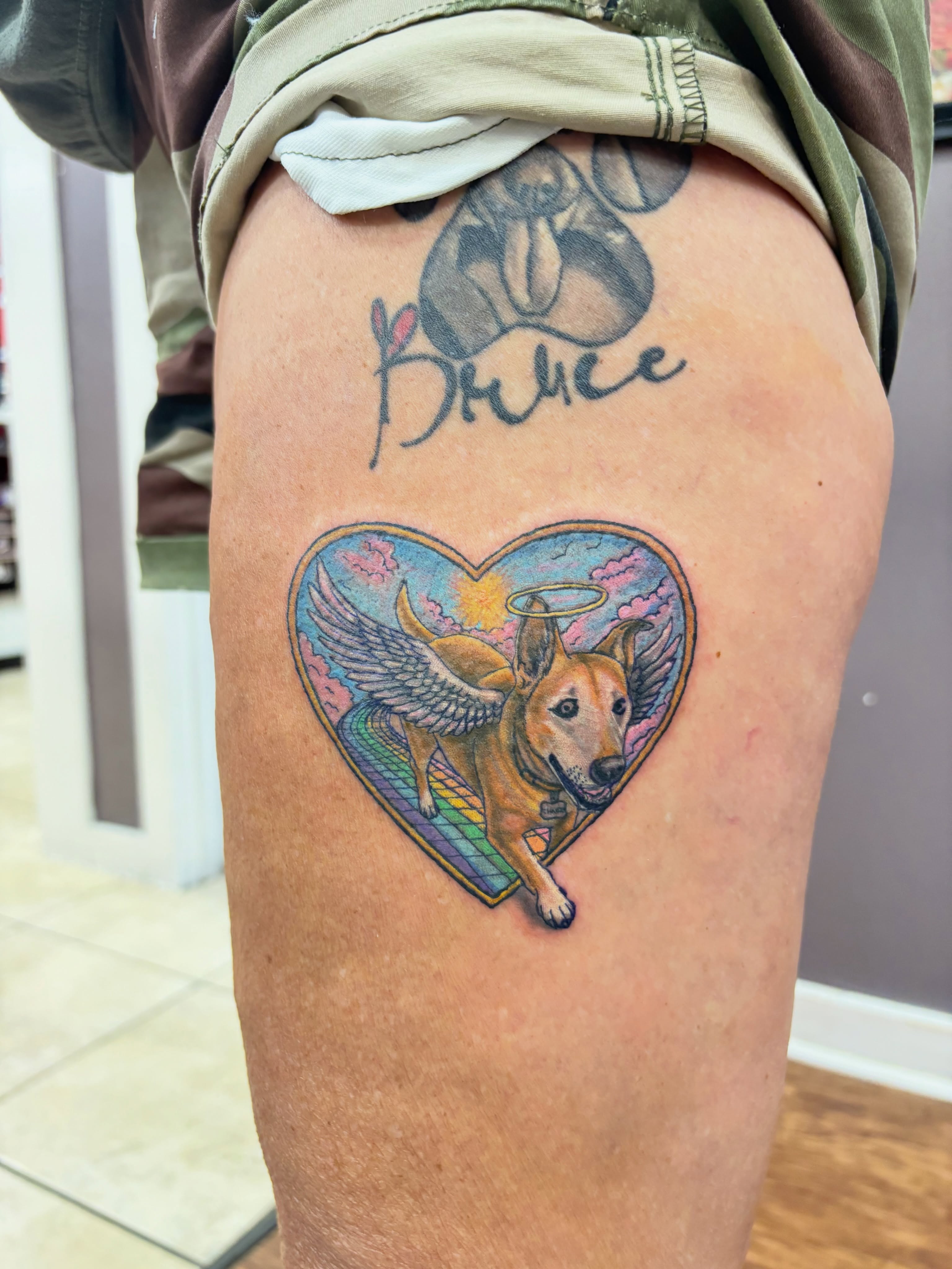 Dog with wings realism tattoo on the thigh by Thom Johns-Green
