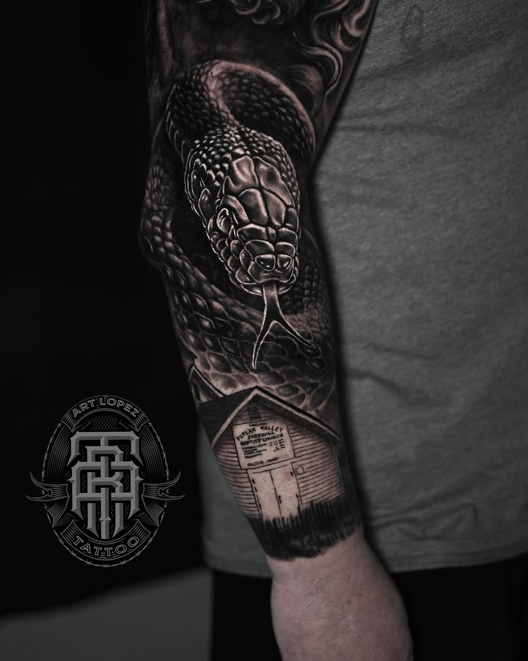 Snake and building realism tattoo on the forearm by Art Lopez