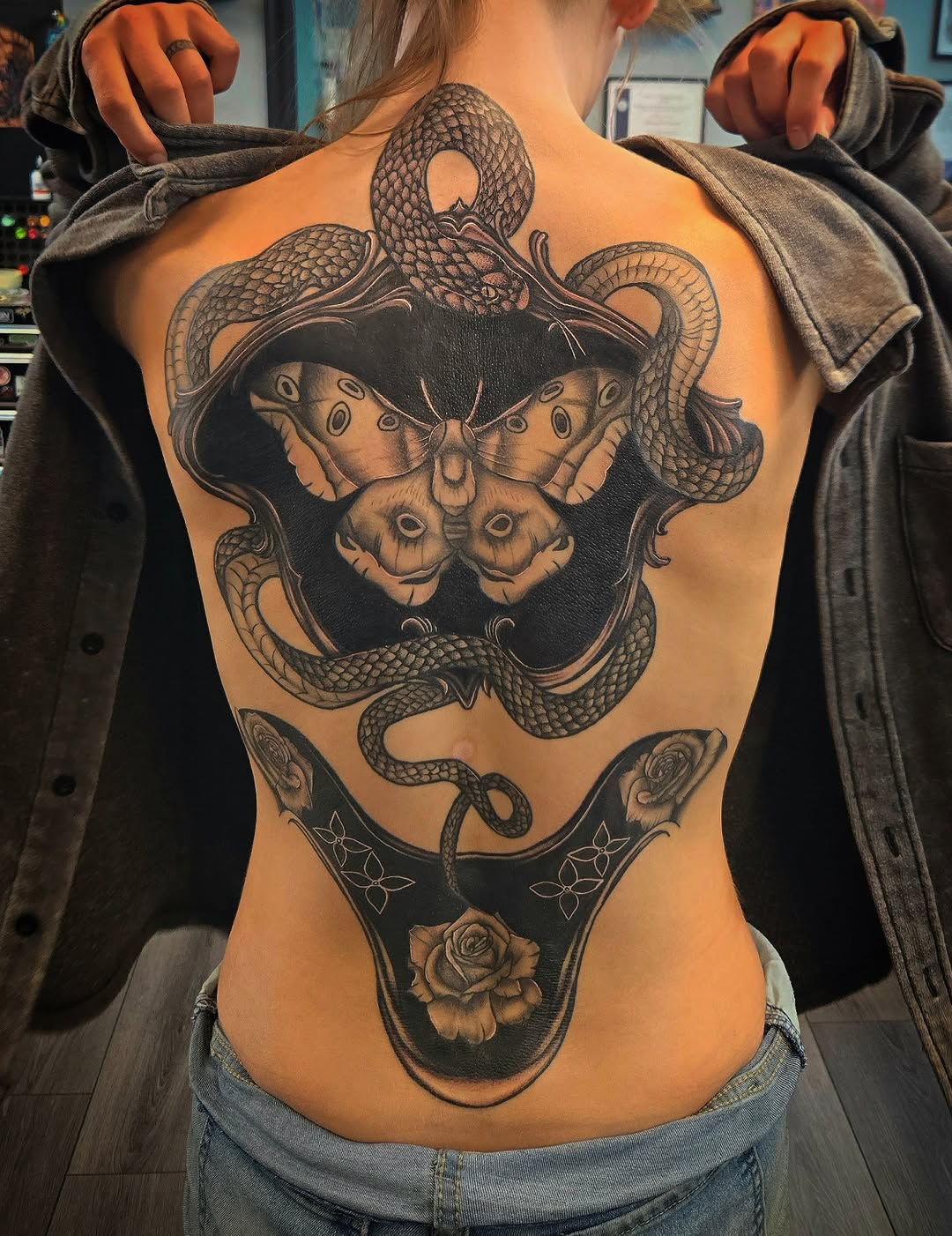 Snake and moth with roses geometric tattoo on the back by Danielle Elizabeth