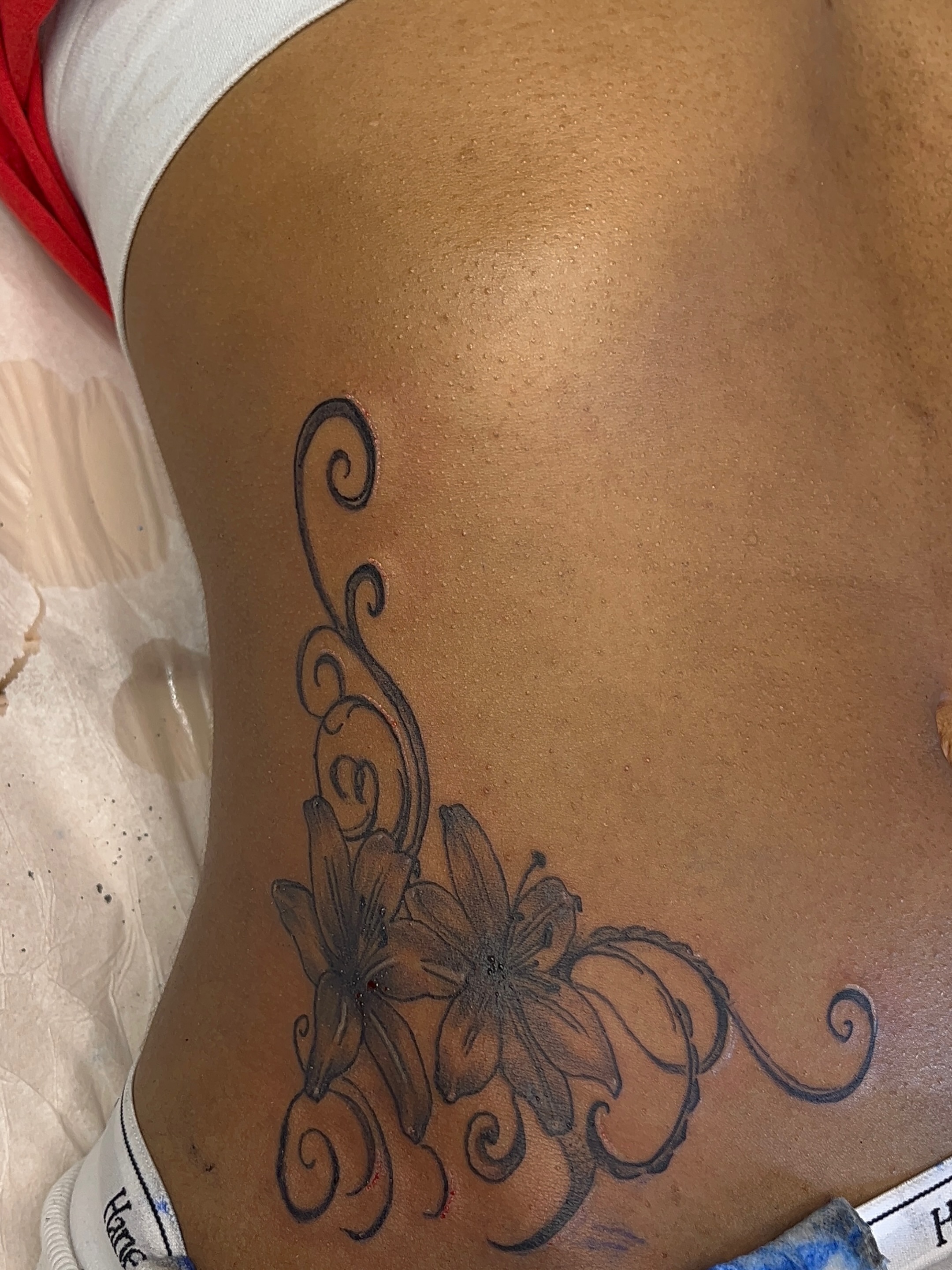 Flowers black and grey tattoo on the ribs by The inspo