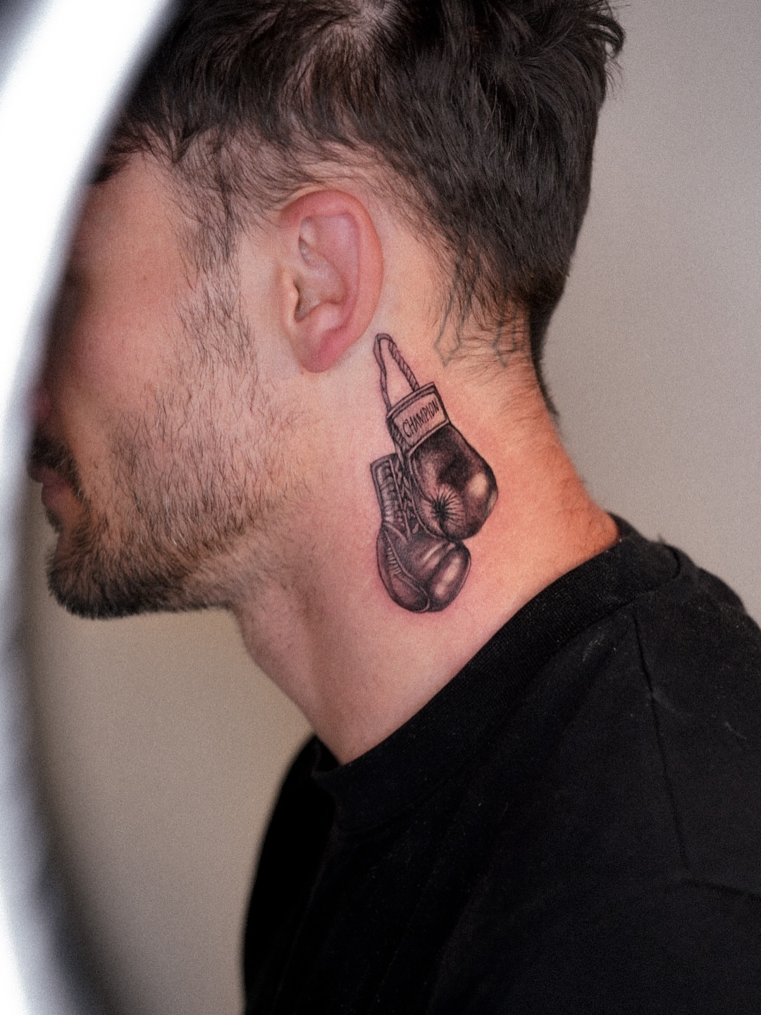 Boxing glove black and grey tattoo on the neck by Joy Christiana