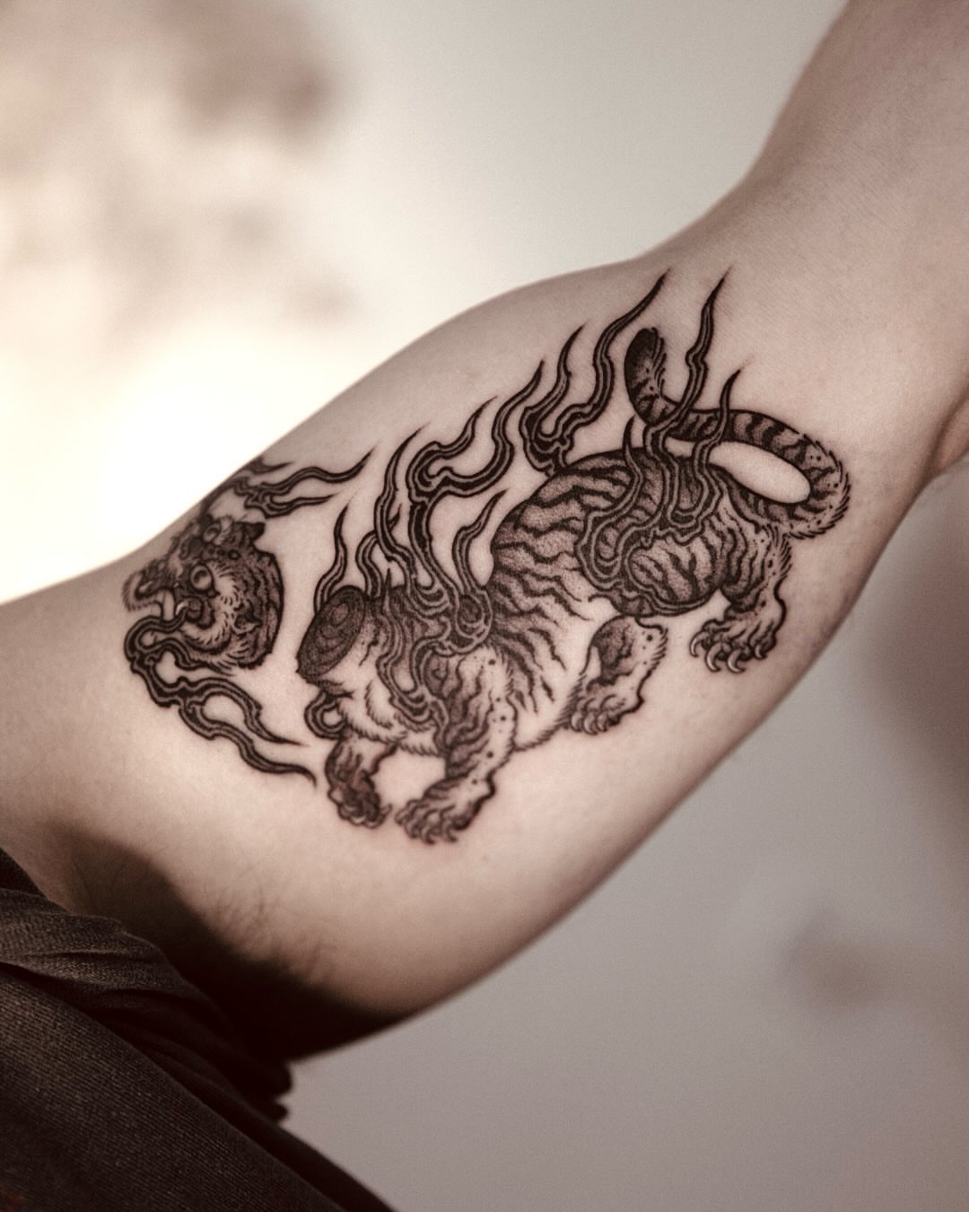 Lion and dragon black and grey tattoo on the forearm by 홍대타투
