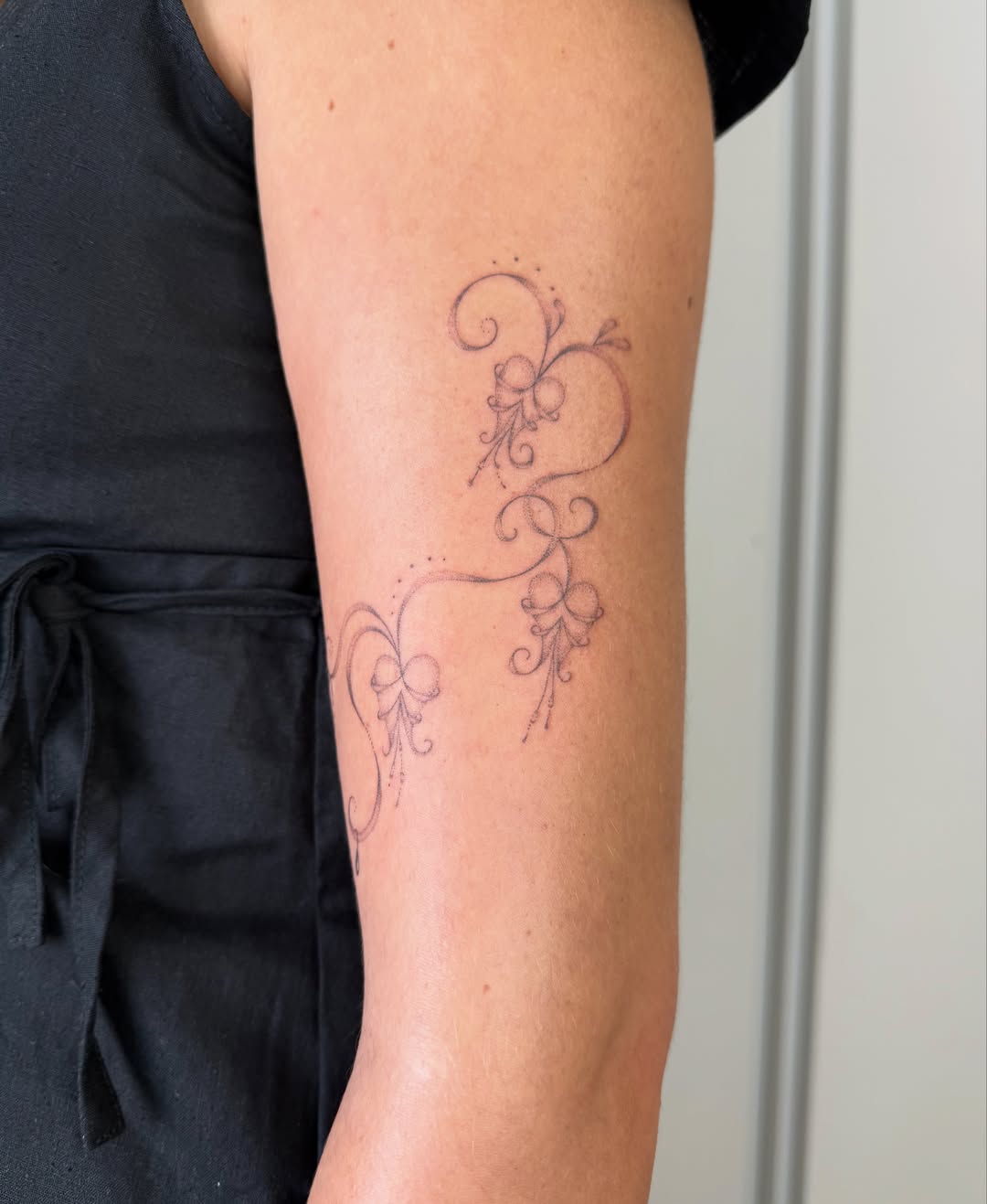 Floral swirls fine line tattoo on the forearm by Soomin