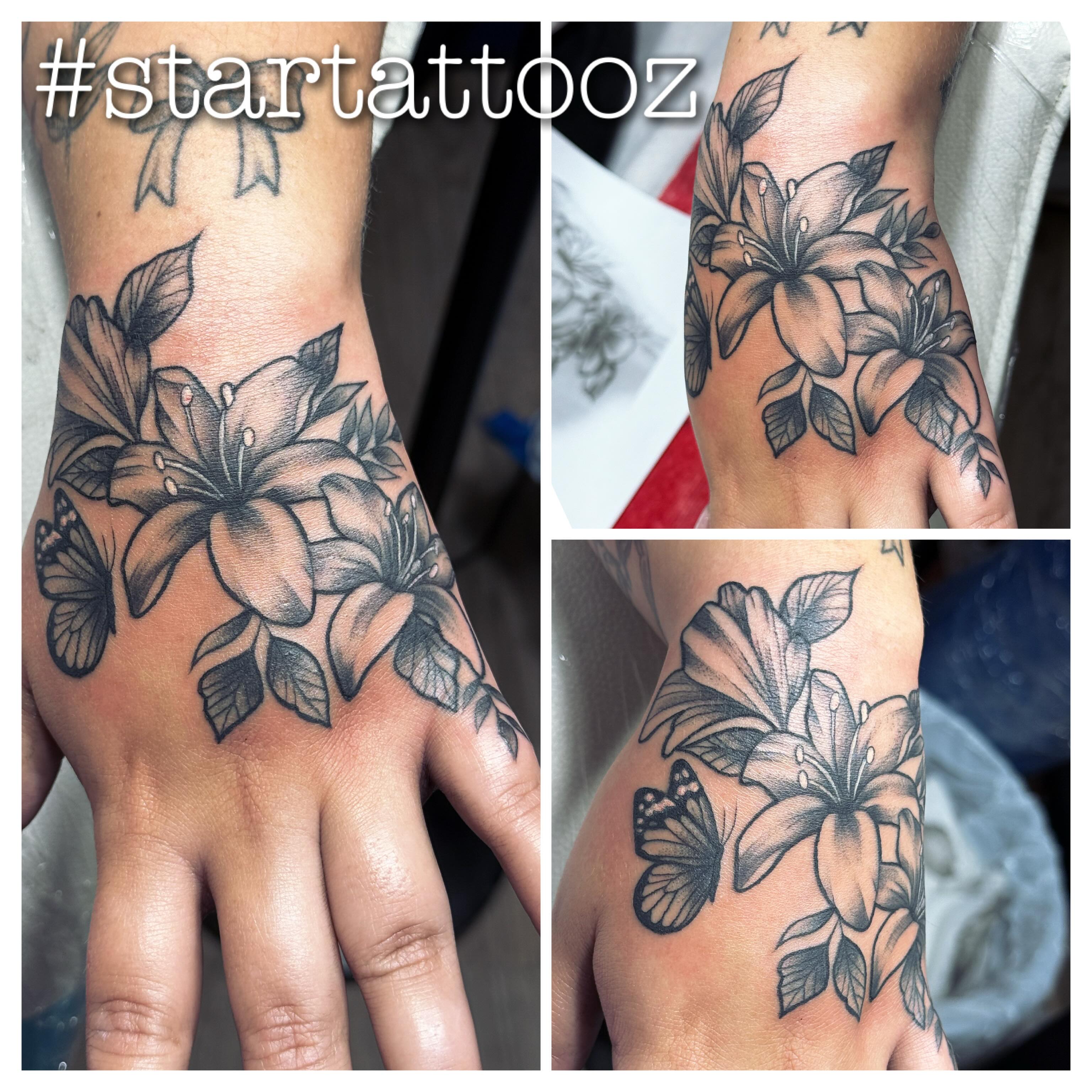 Lilies and butterfly black and grey tattoo on the forearm by StarTattooz - the one & only