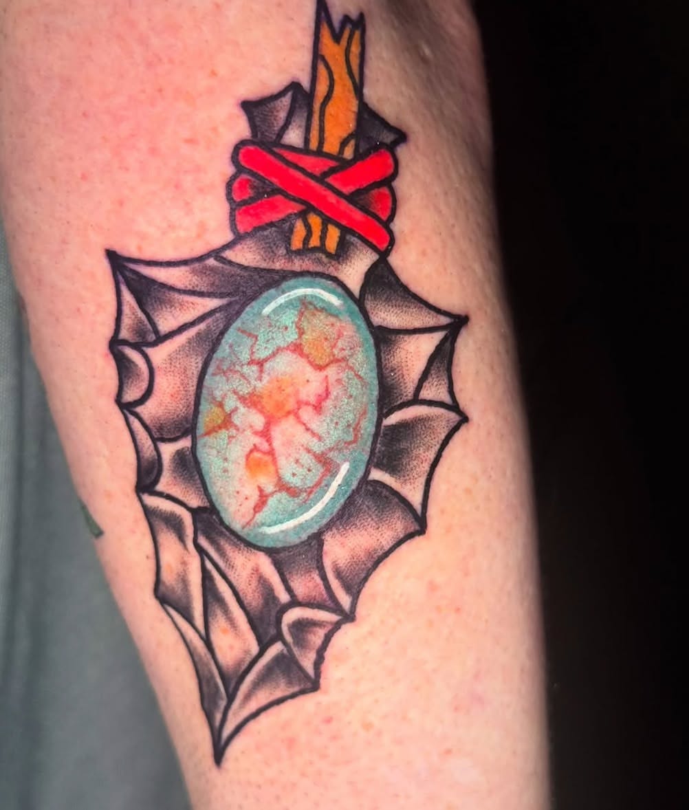 Gemstone pendant American traditional tattoo on the forearm by Kenneth Gibson