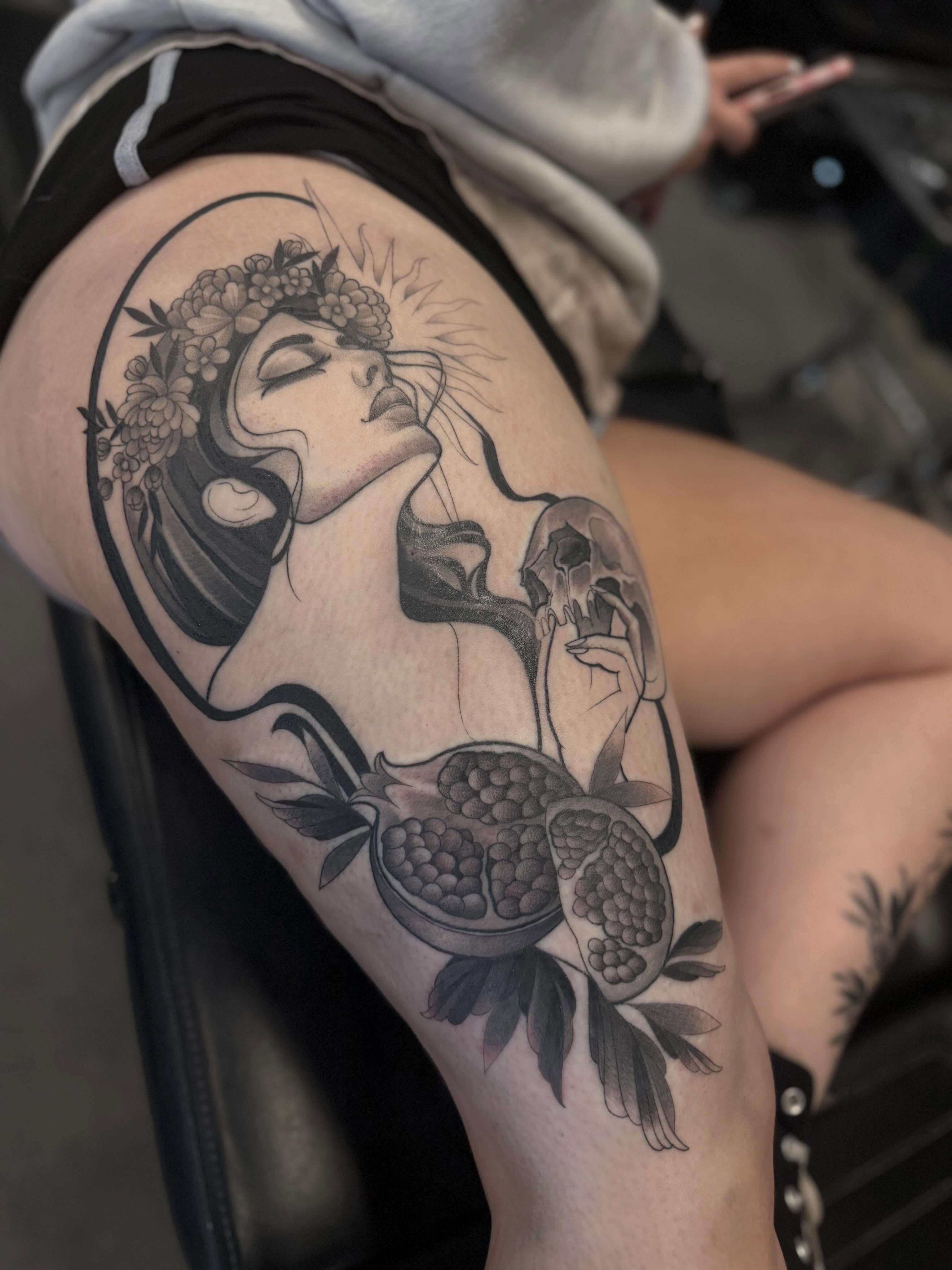 Woman with flowers and pomegranate realism tattoo on the thigh by Srey Grace