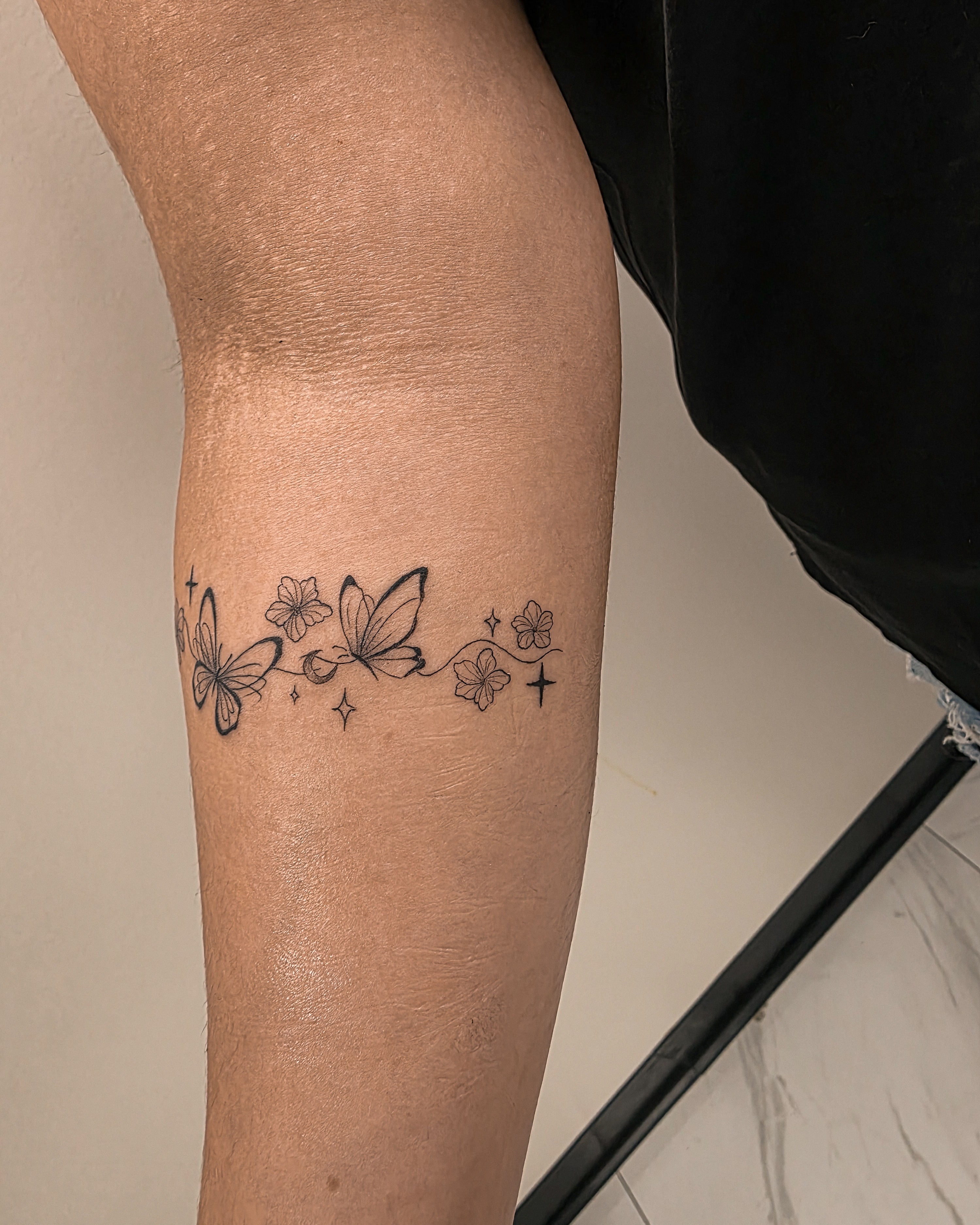 Butterflies and flowers black and grey tattoo on the leg by Richmond tattoo shop, Richmond, Texas