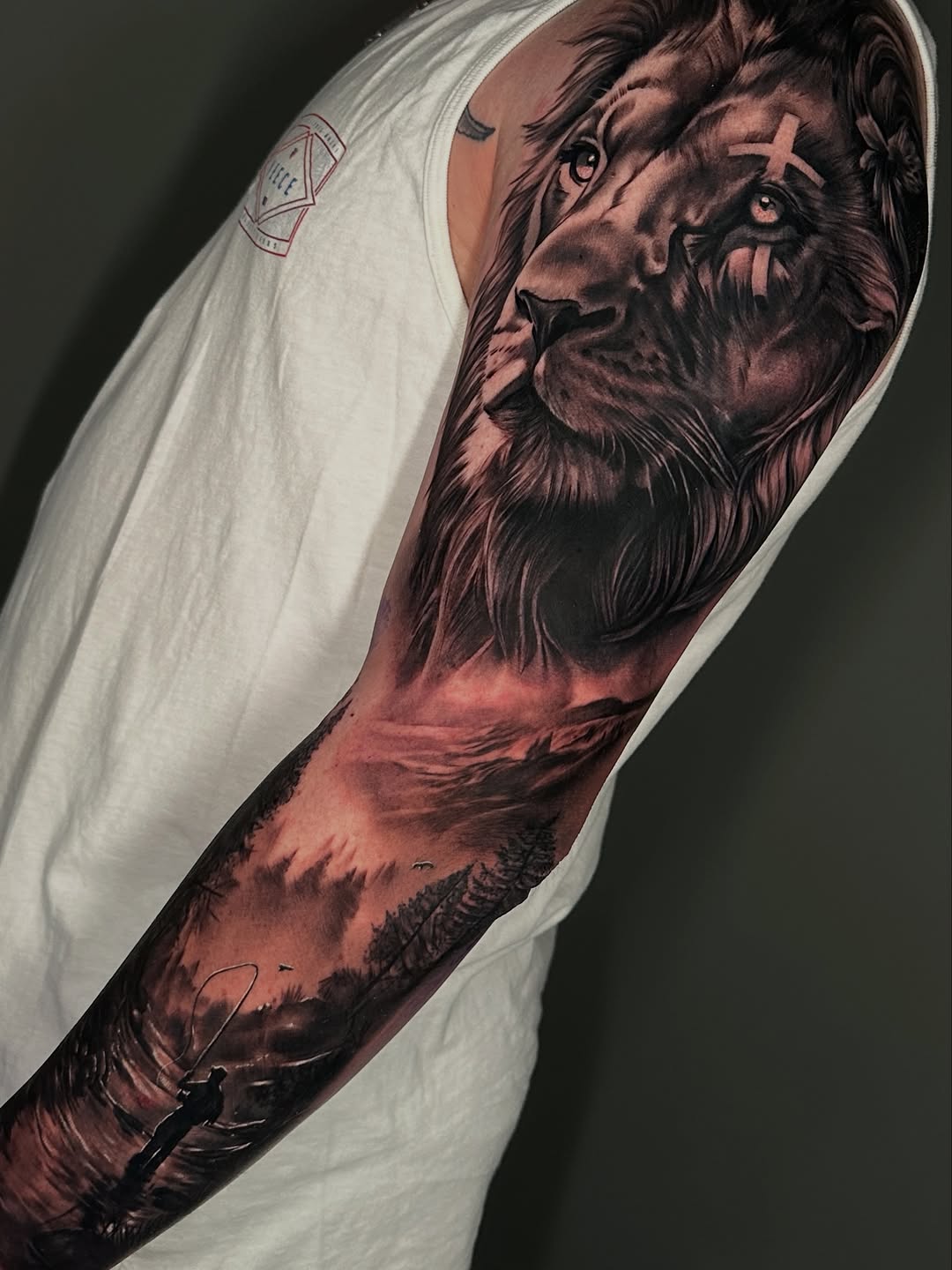 Lion and landscape with fisherman Japanese tattoo on the forearm by Dakota Case