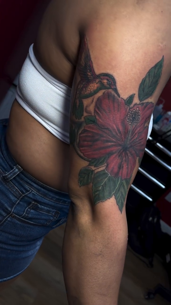 Hummingbird and hibiscus flower tattoo neo-traditional tattoo on the upper arm by Mike Tatts