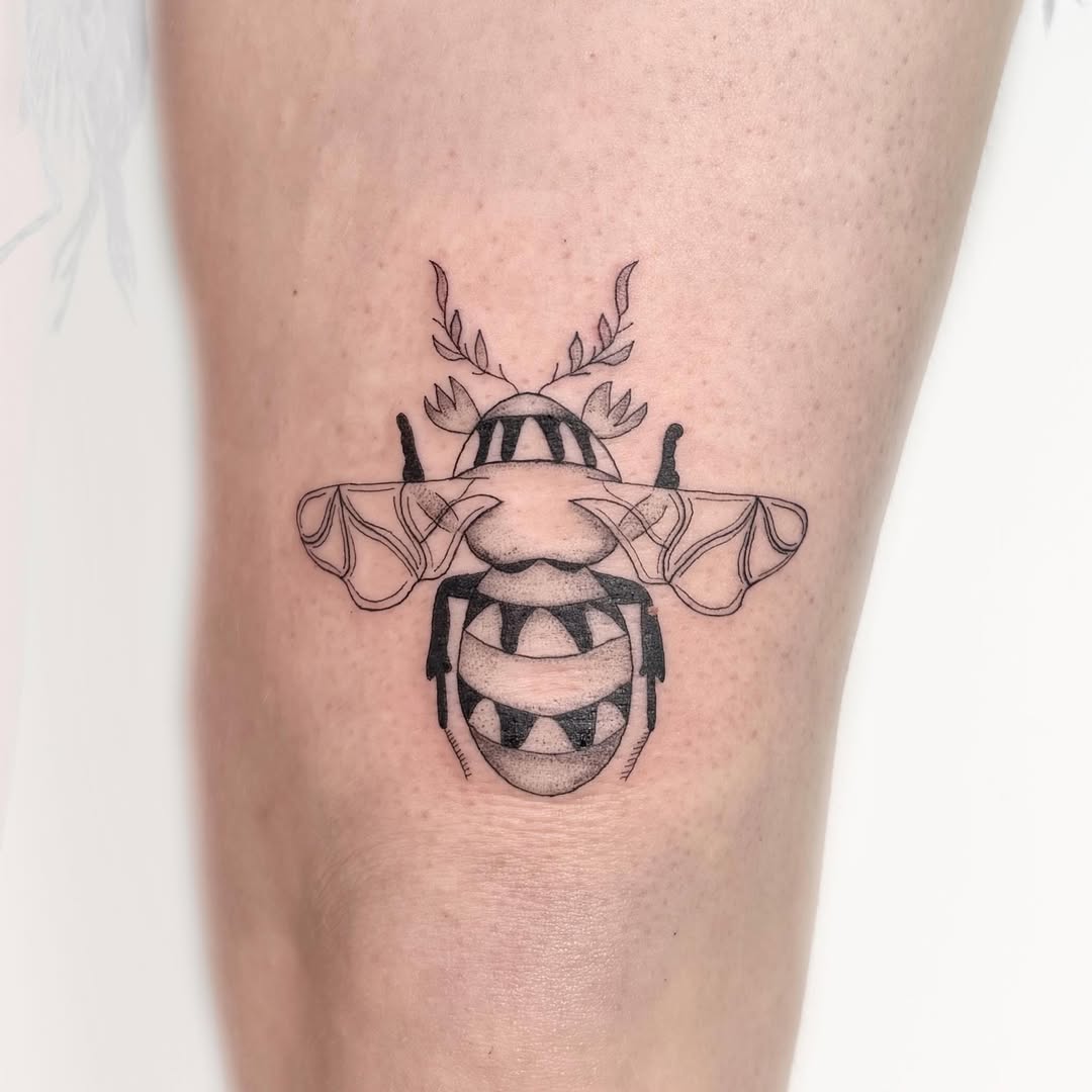 Stylized bee with floral elements fine line tattoo on the thigh by Nika