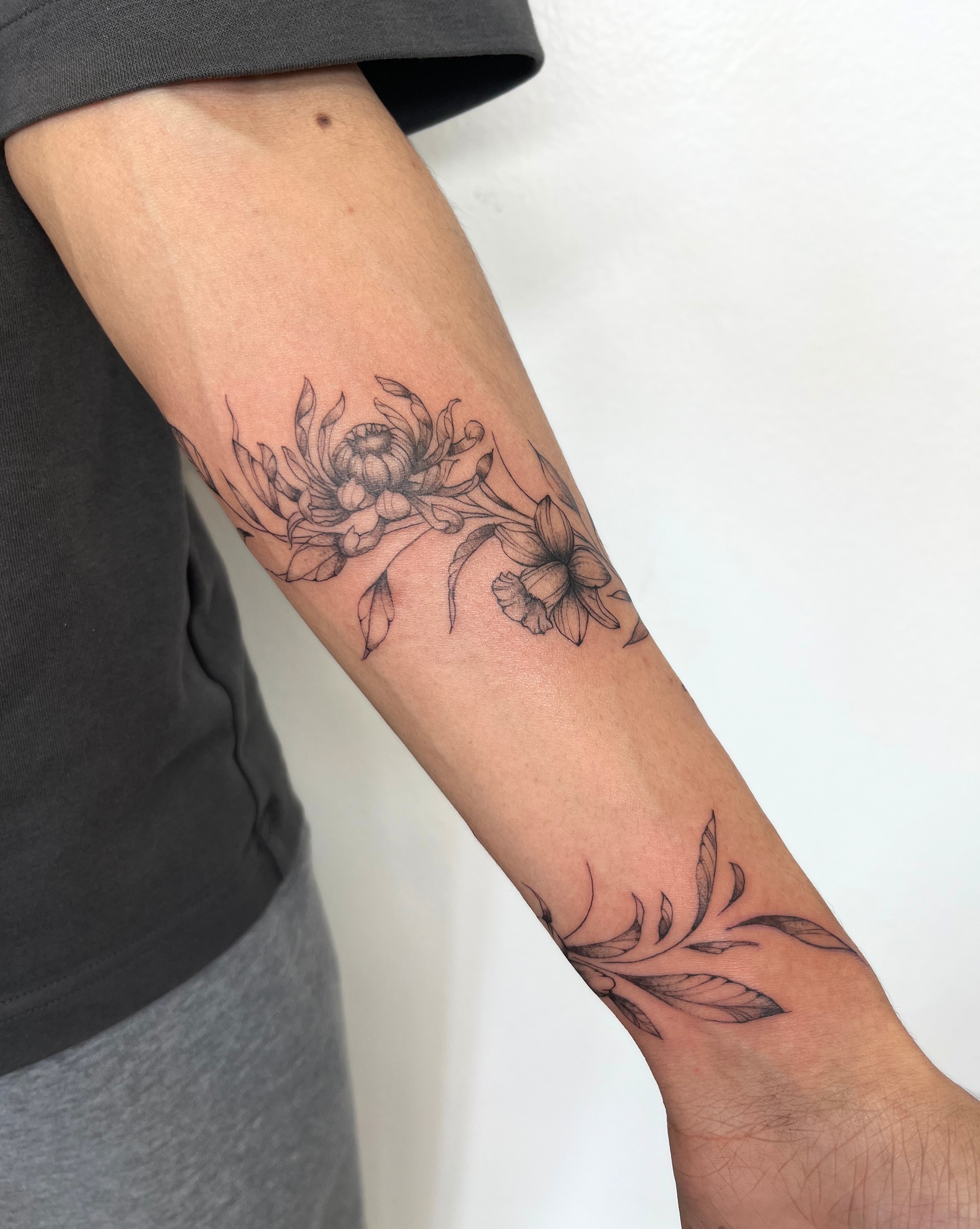 Floral arrangement black and grey tattoo on the forearm by kt