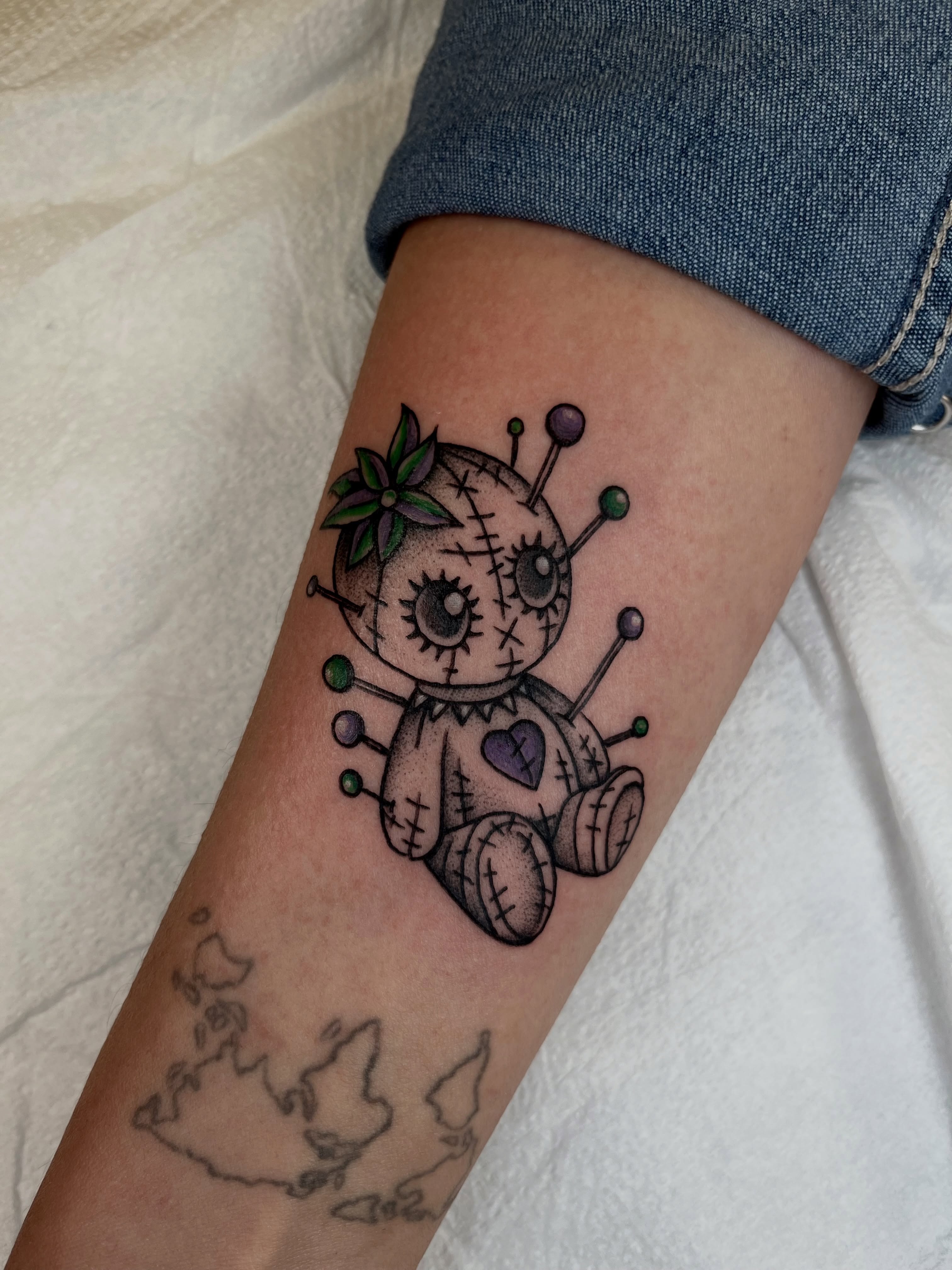 Voodoo doll black and grey tattoo on the forearm by Patrick Elijah