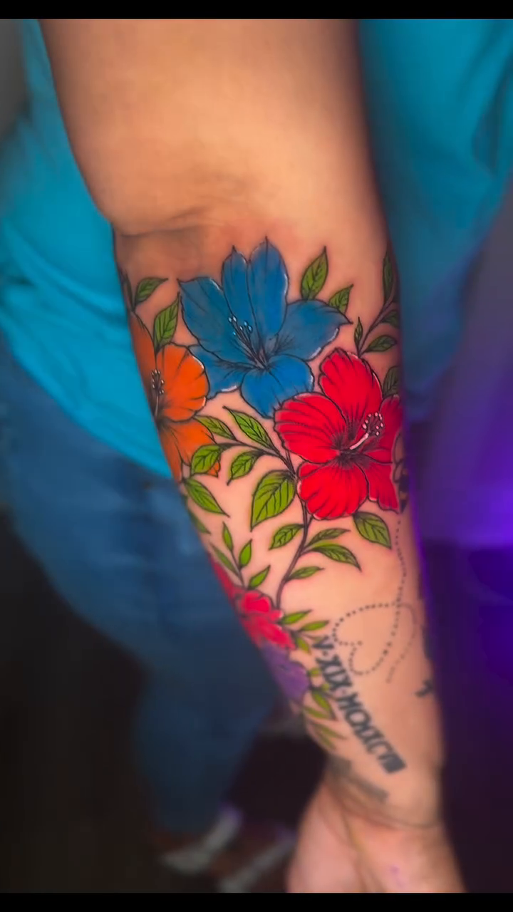 Floral sleeve with hibiscus flowers watercolor tattoo on the forearm by InkedByJide Tattoo, Atlanta, Georgia
