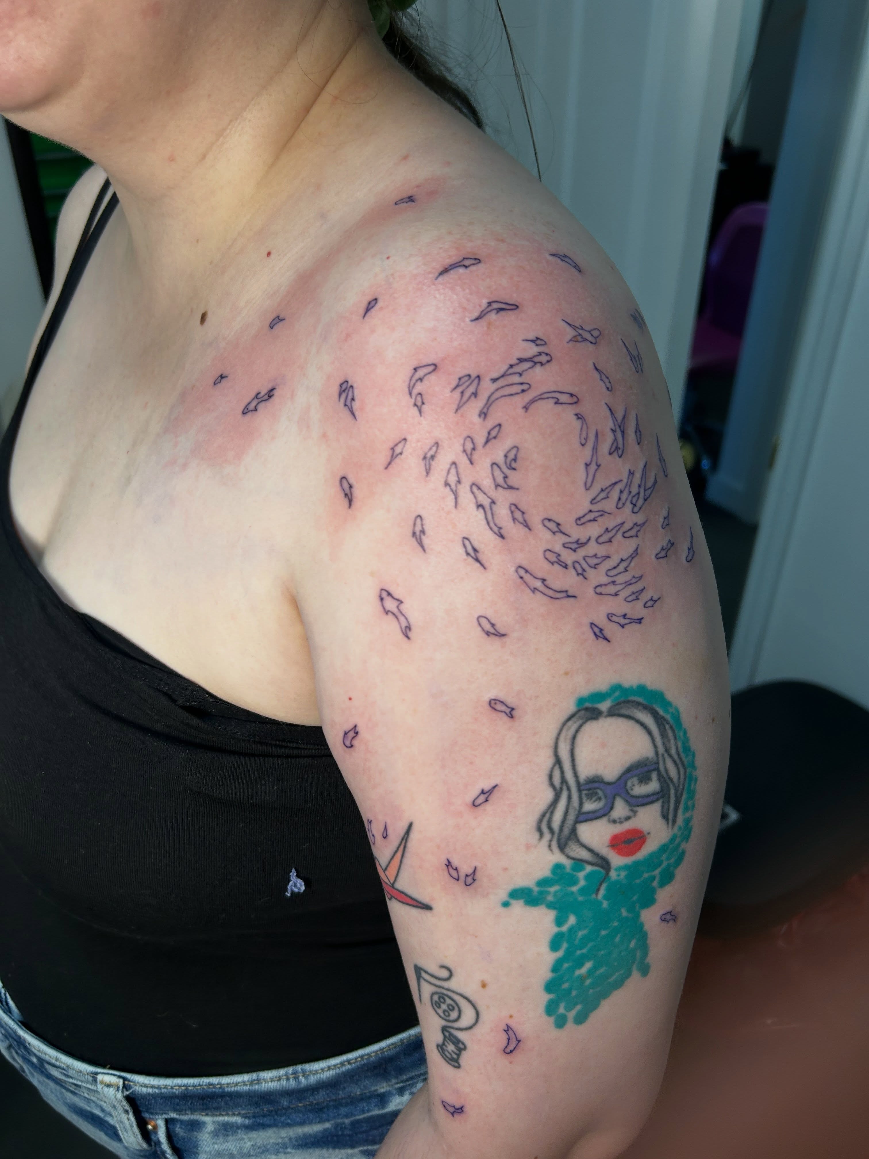 Fish school dotwork tattoo on the shoulder by Mattie Robinson