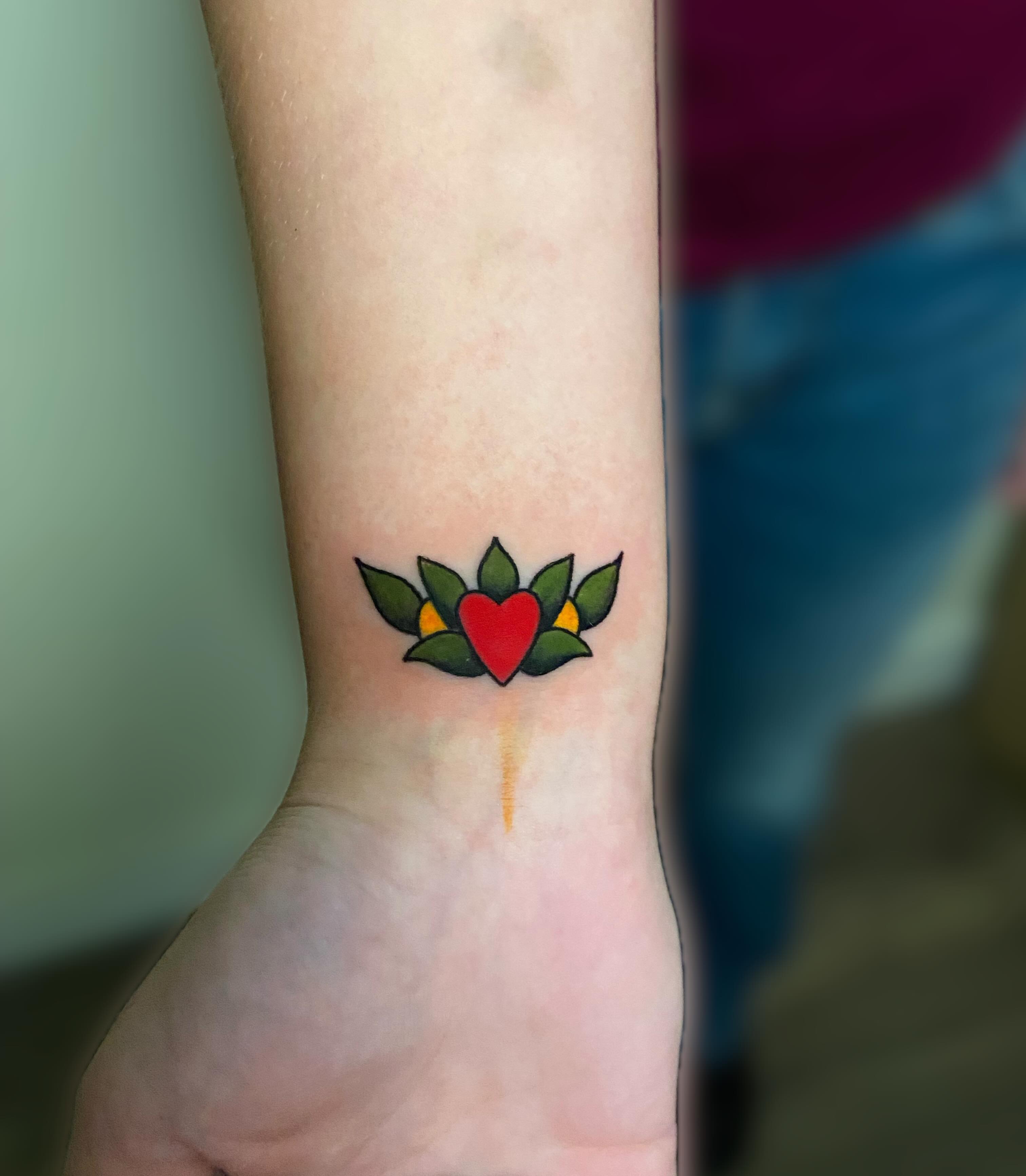 Heart with leaves American traditional tattoo on the forearm by Ezra Gonda