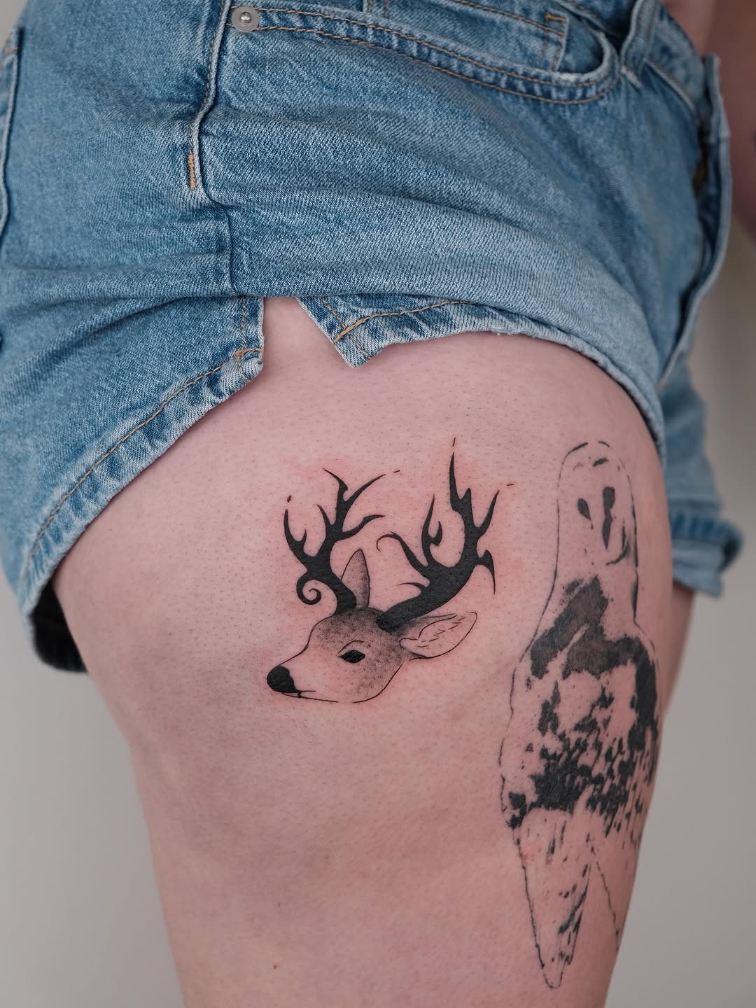 Deer head fine line tattoo on the thigh by Elana Hites