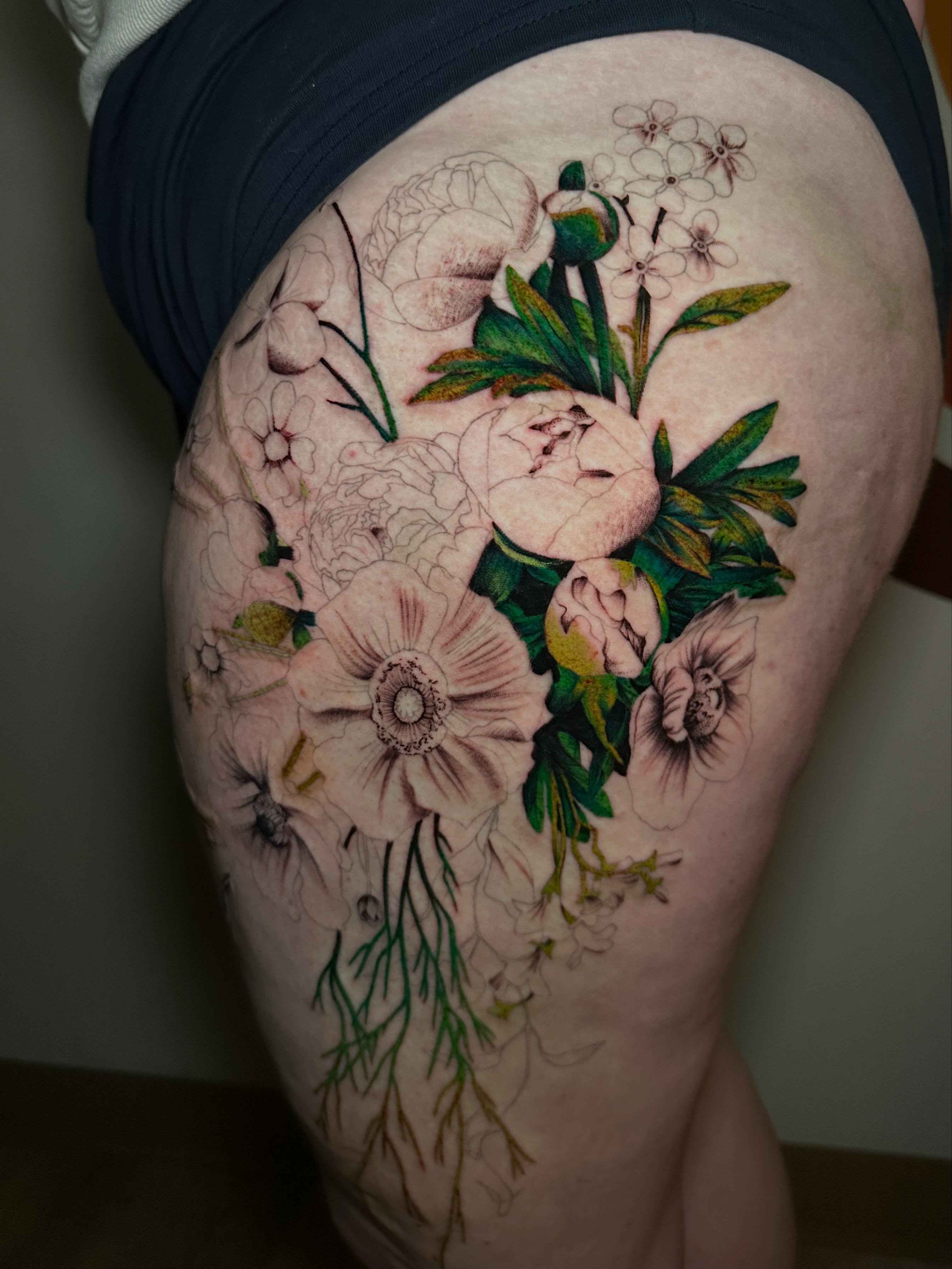 Floral bouquet realism tattoo on the thigh by Les