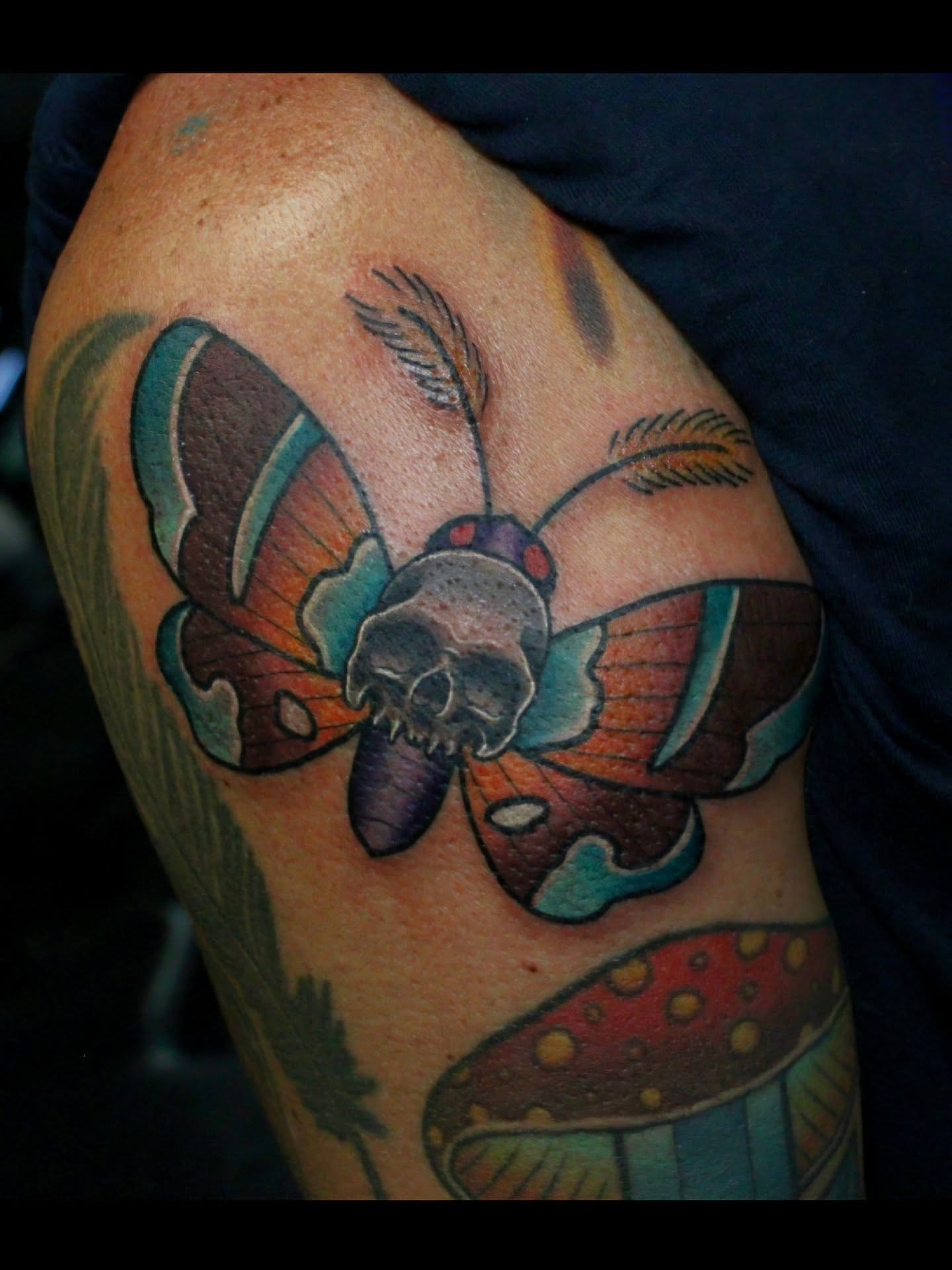 Butterfly skull American traditional tattoo on the upper arm by Joey Vinci, Phoenix, Arizona
