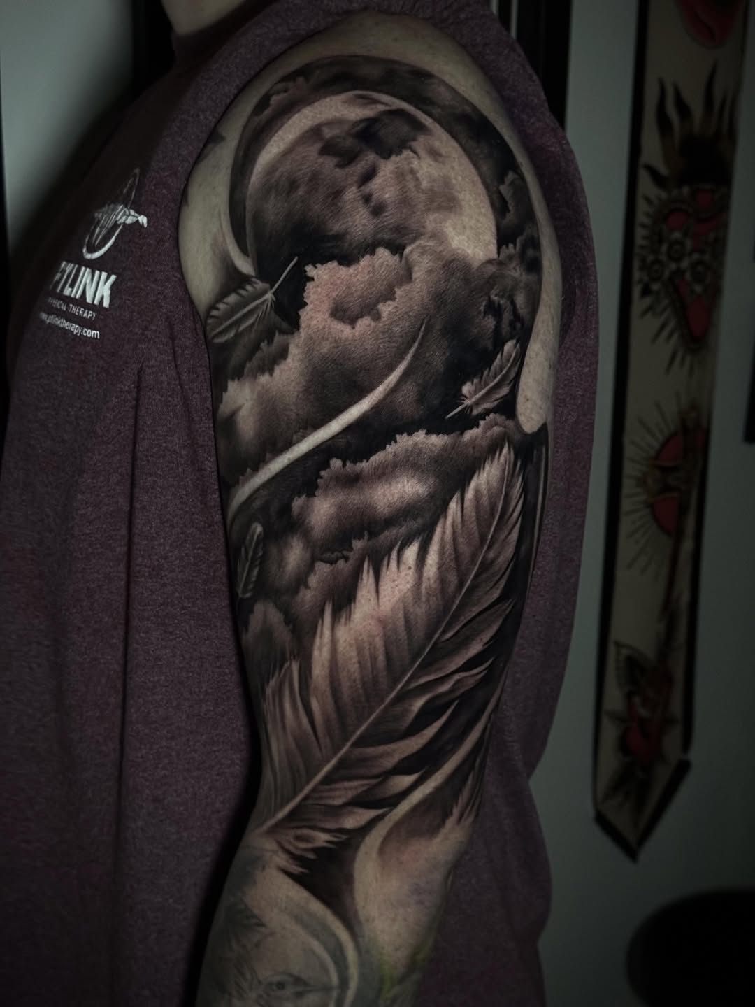 Moon and feathers realism tattoo on the upper arm by Tony Garcia