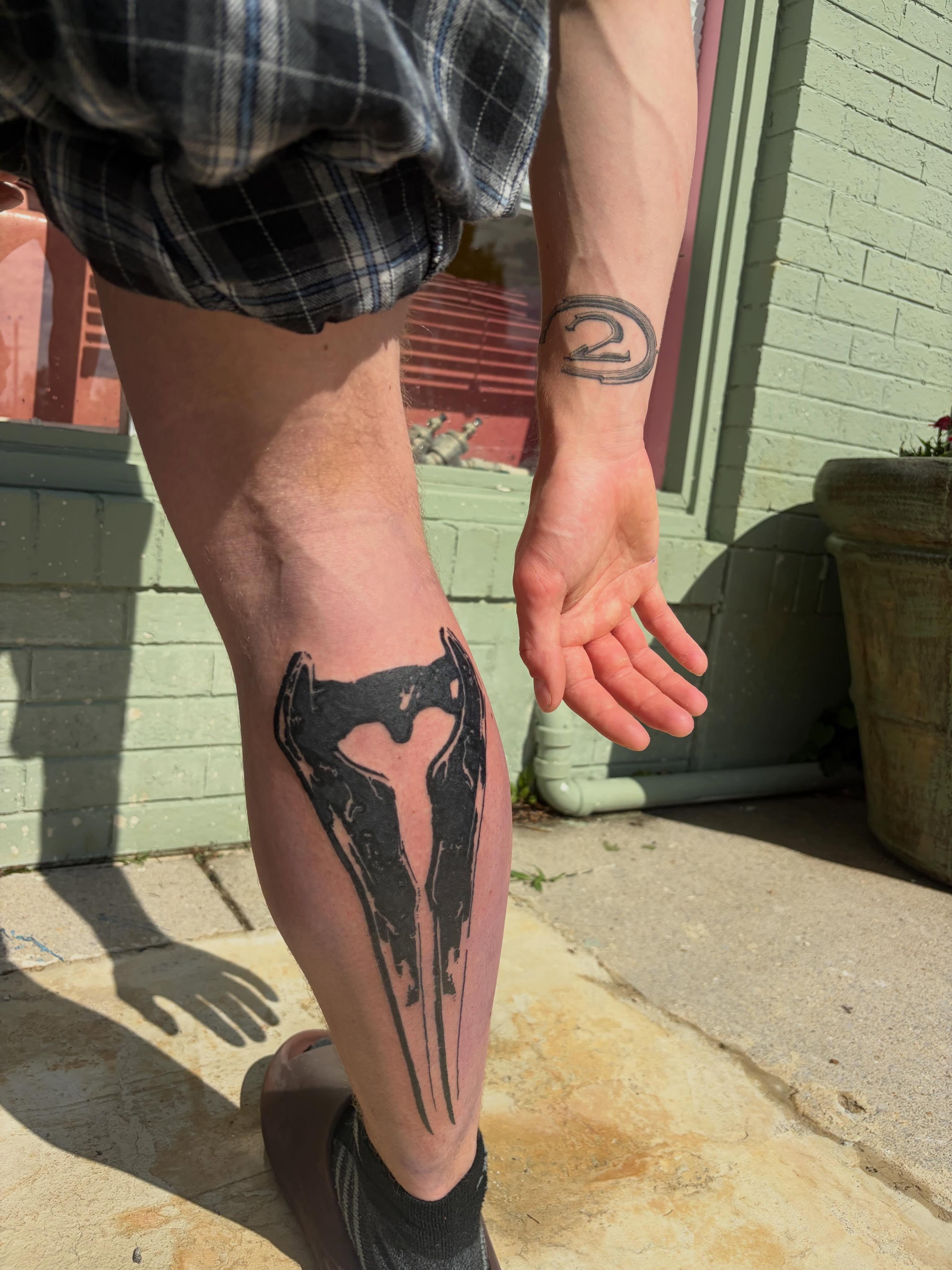 Mask black and grey tattoo on the calf by neal