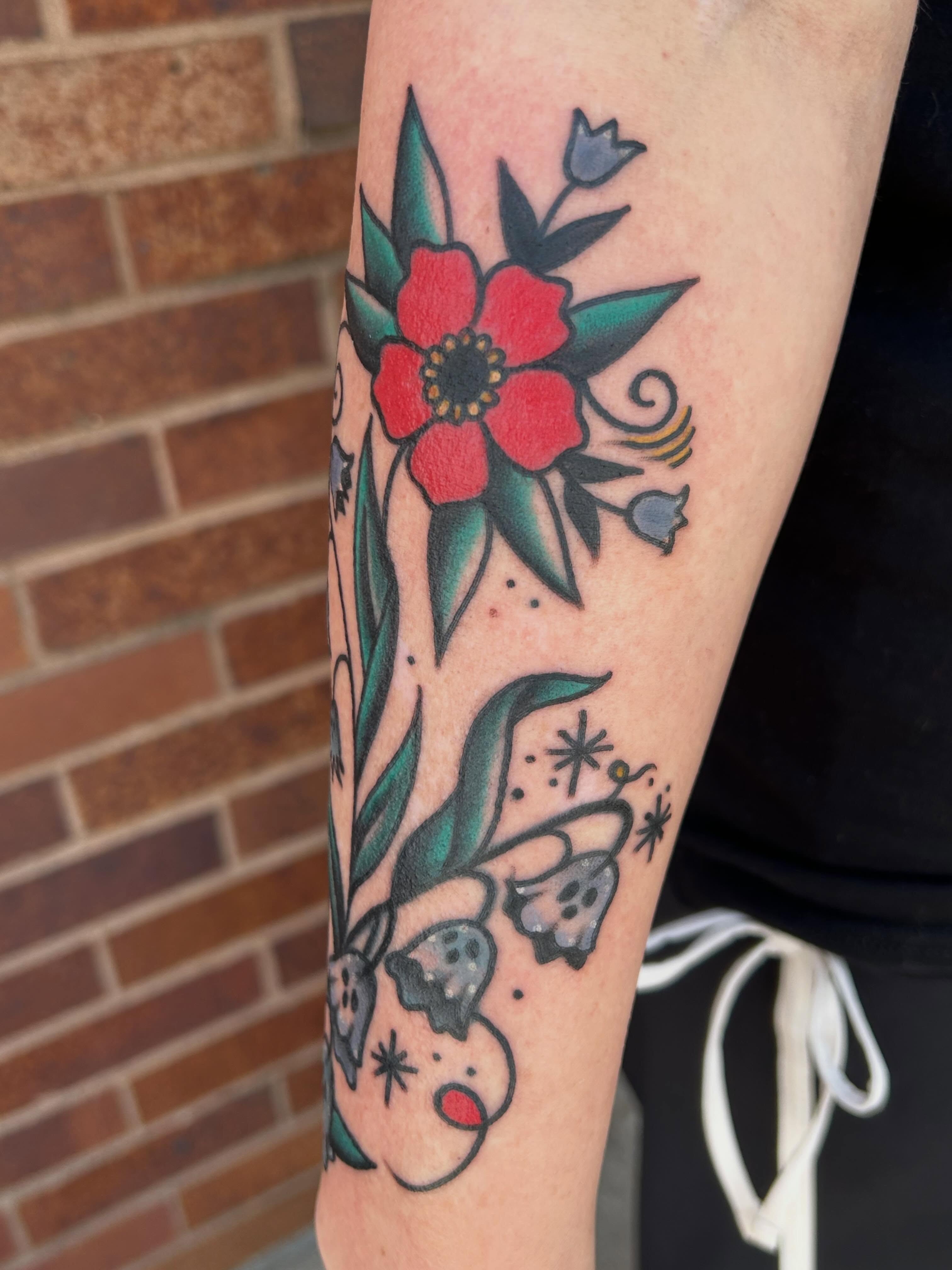 Floral arrangement American traditional tattoo on the forearm by Morgan Hazer Tattoos, Cedar Rapids, Iowa