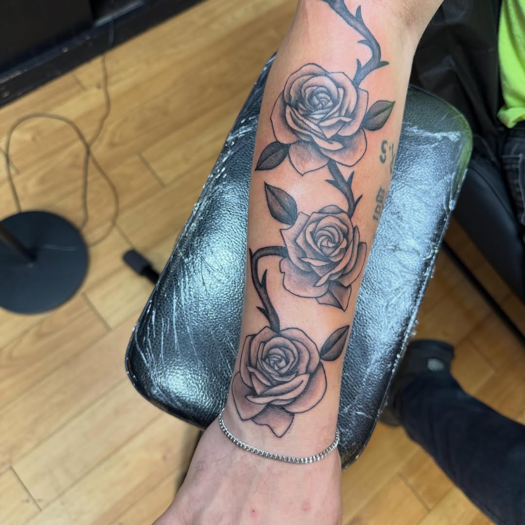 Roses black and grey tattoo on the forearm by Nic