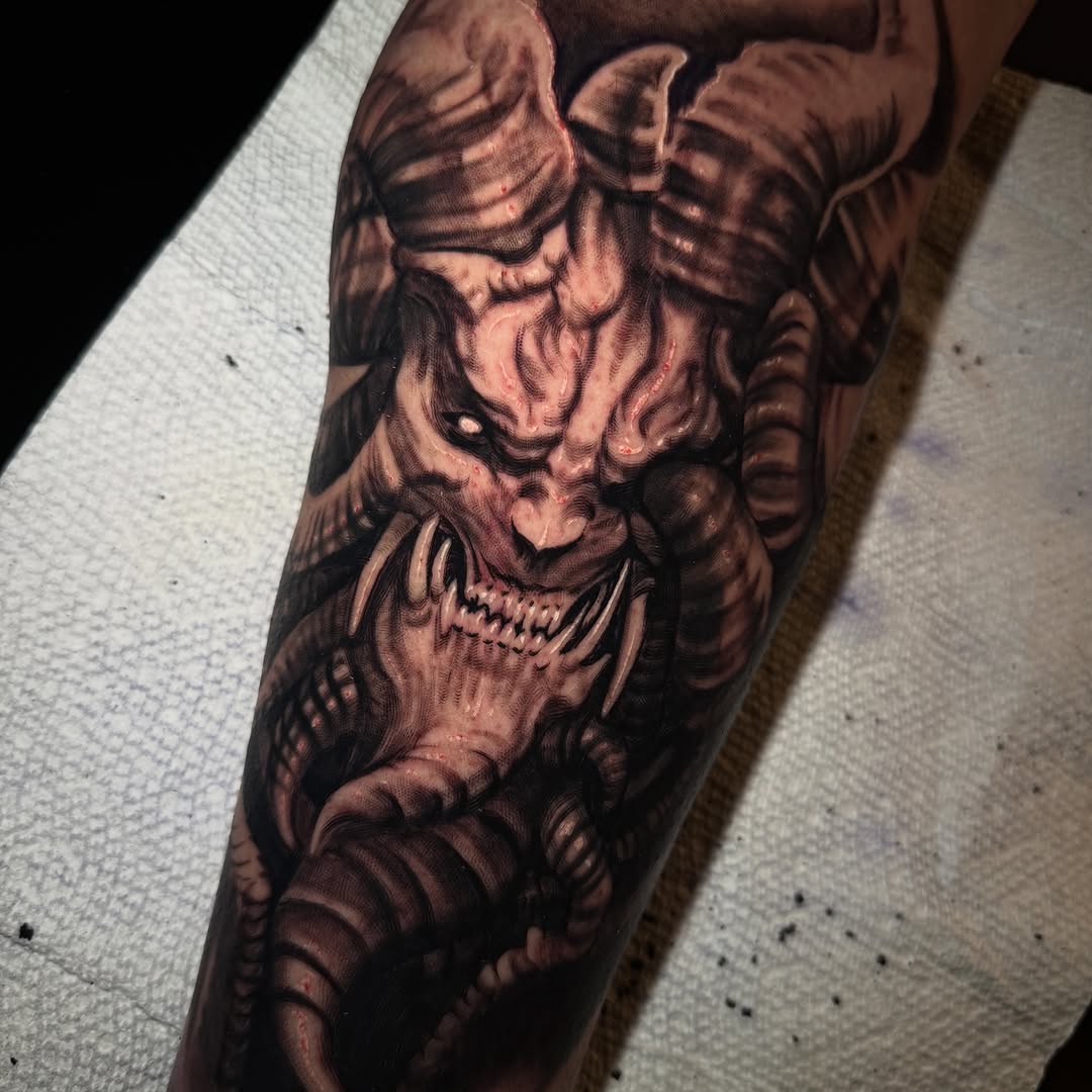 Demon face with horns realism tattoo on the forearm by Jake Fujimura
