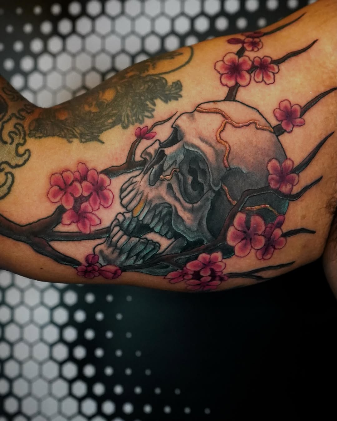 Cherry blossoms and skull japanese irezumi tattoo on the forearm by Gina Carlson