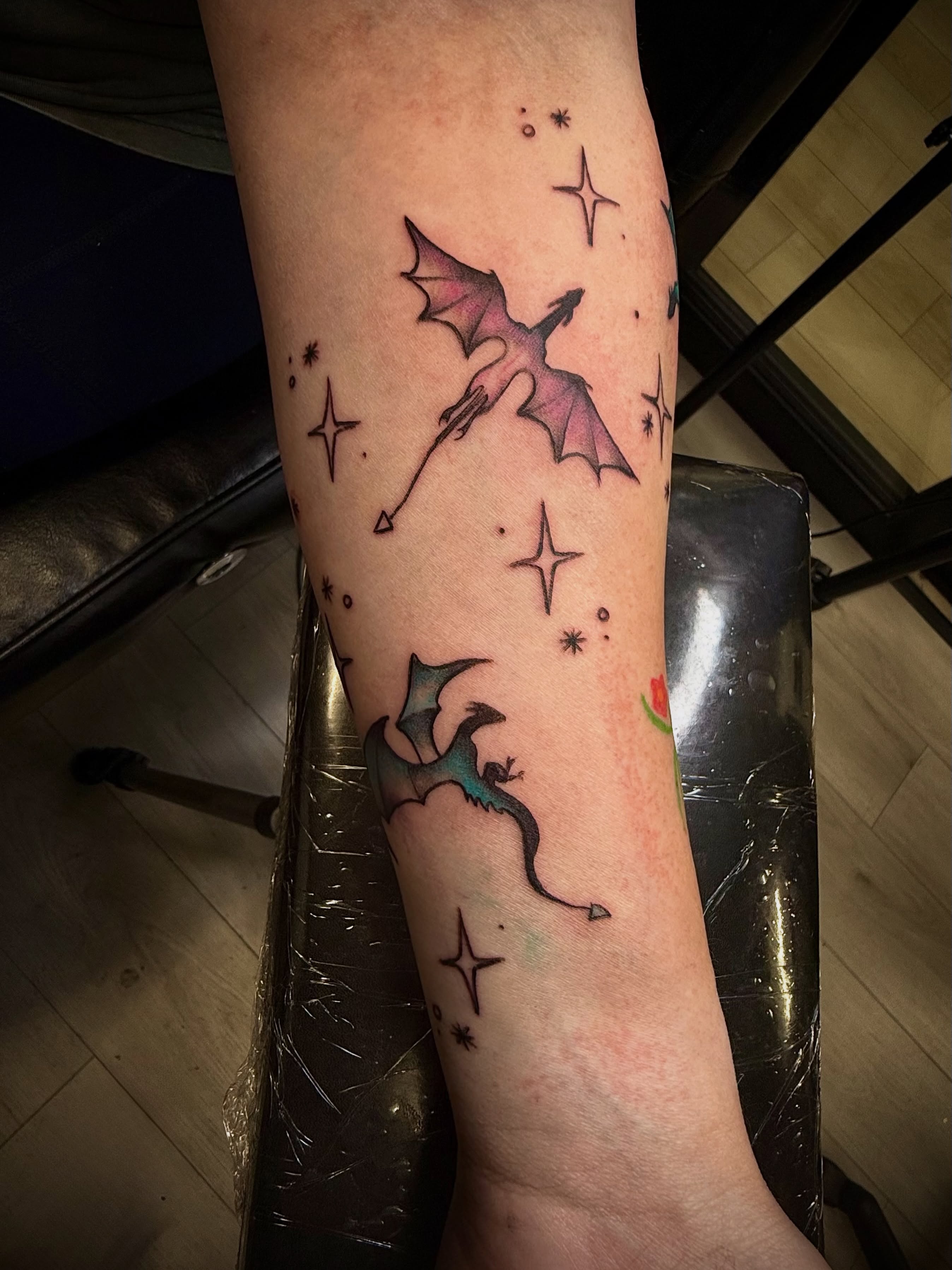 Dragons and stars dotwork tattoo on the forearm by Jennifer Contreras