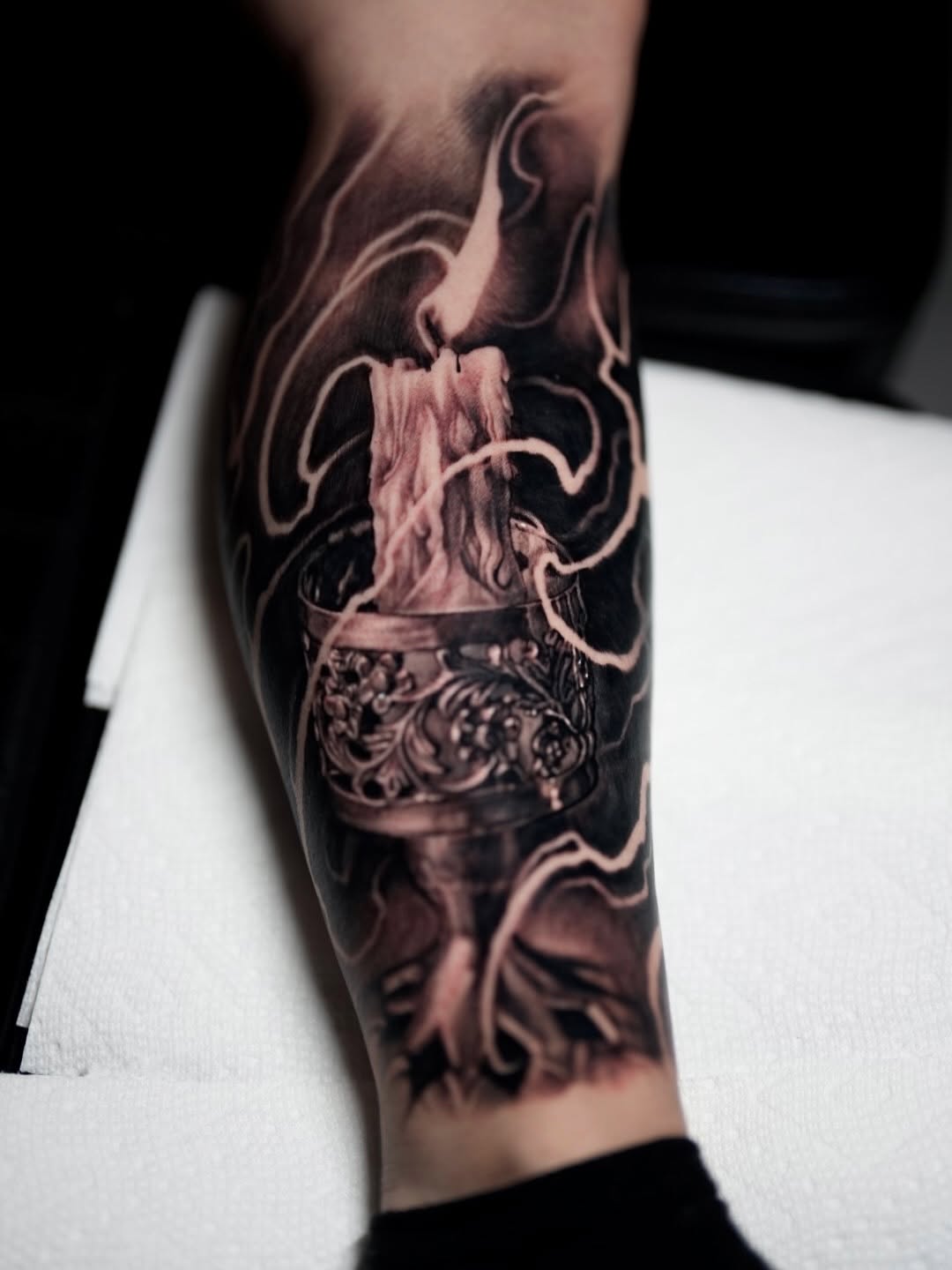 Candle and ornate stand surrealism tattoo on the forearm by Nico Perez