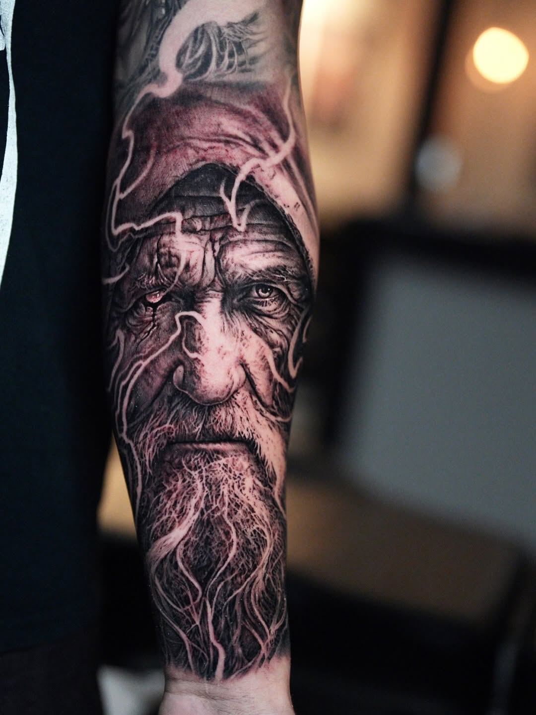 Old man's face with beard realism tattoo on the forearm by Nico Perez