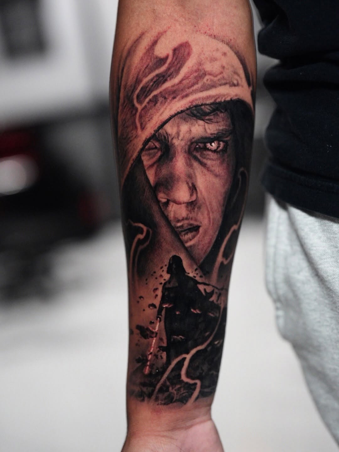 Man in hood with lightsaber realism tattoo on the forearm by Nico Perez