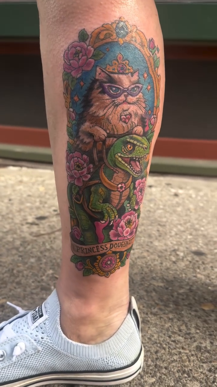 Cat princess with dinosaur and flowers realism tattoo on the forearm by Misty Dawn Brothers, Dayton, Ohio