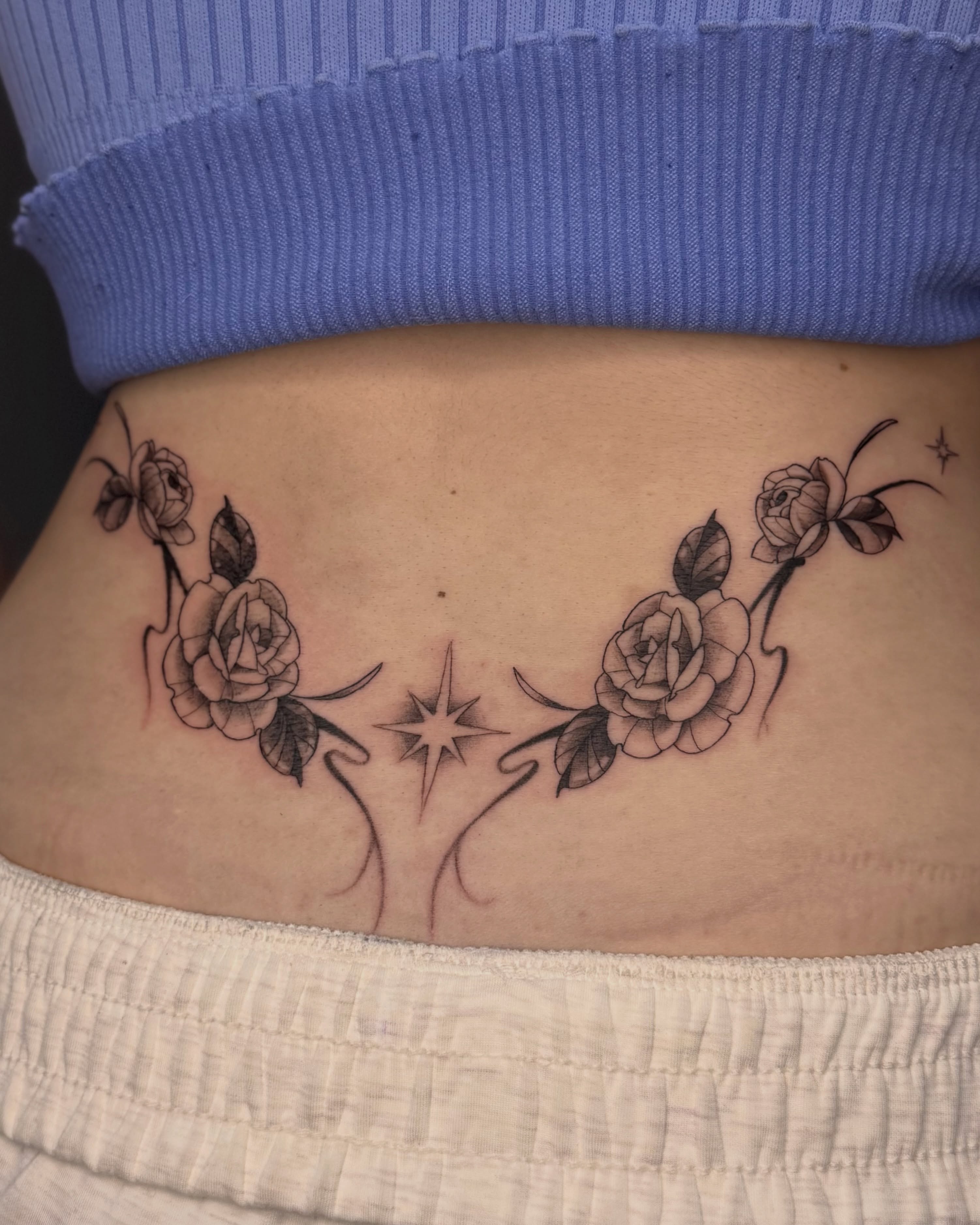 Roses and stars black and grey tattoo on the torso by Suzy