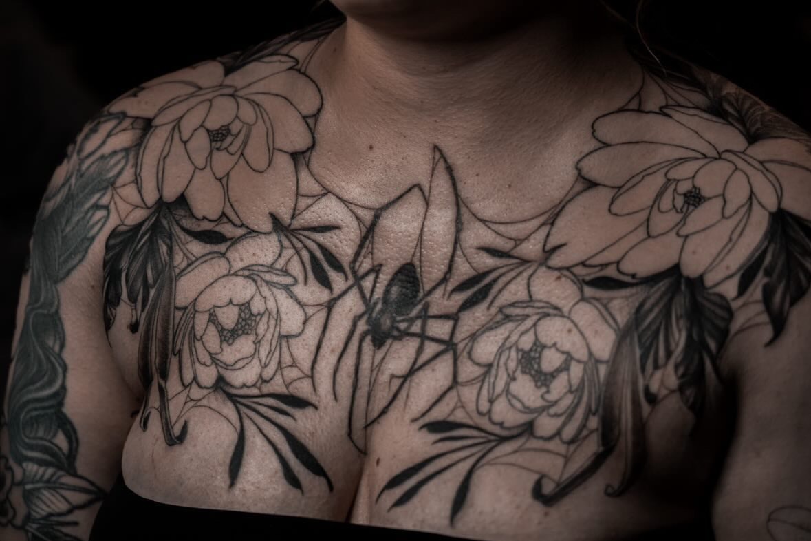 Floral arrangement black and grey tattoo on the chest by Jenn Golgan