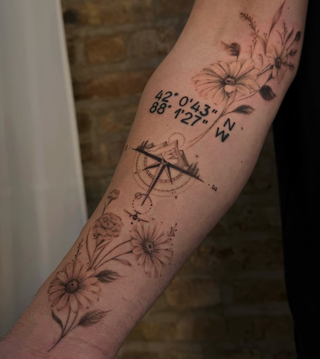 Compass and floral black and grey tattoo on the forearm by Tattoo Yulia Kononenko