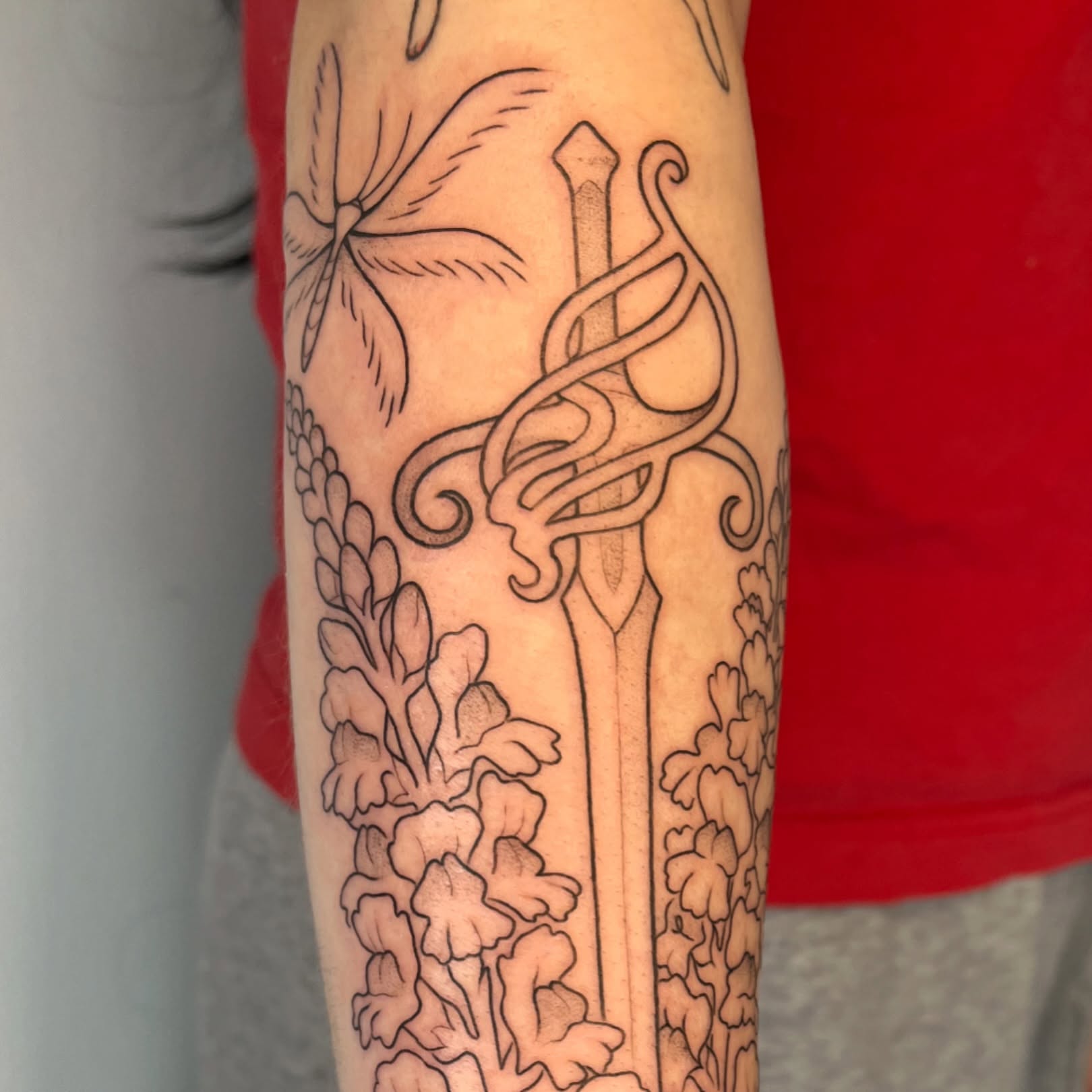 Sword and flowers ornamental tattoo on the forearm by Iggy Montgomery (they