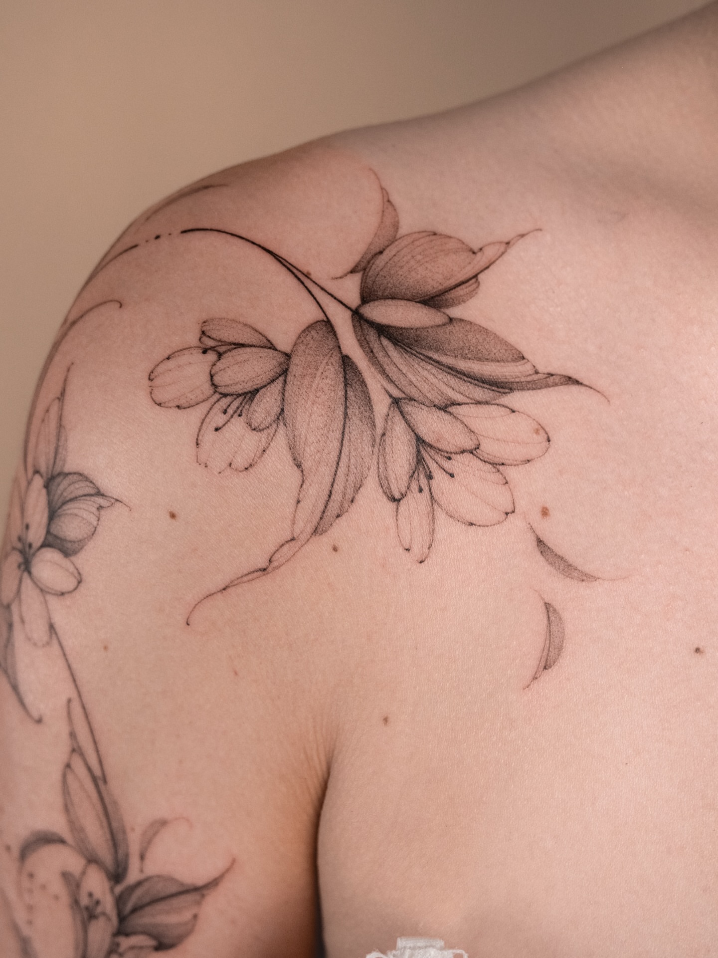 Floral arrangement black and grey tattoo on the shoulder by i flower you