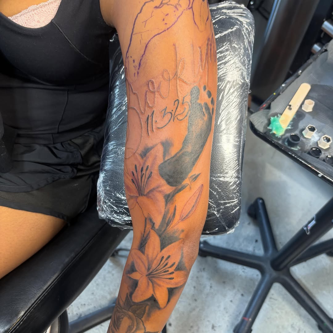 Lilies black and grey tattoo on the forearm by D. Davis