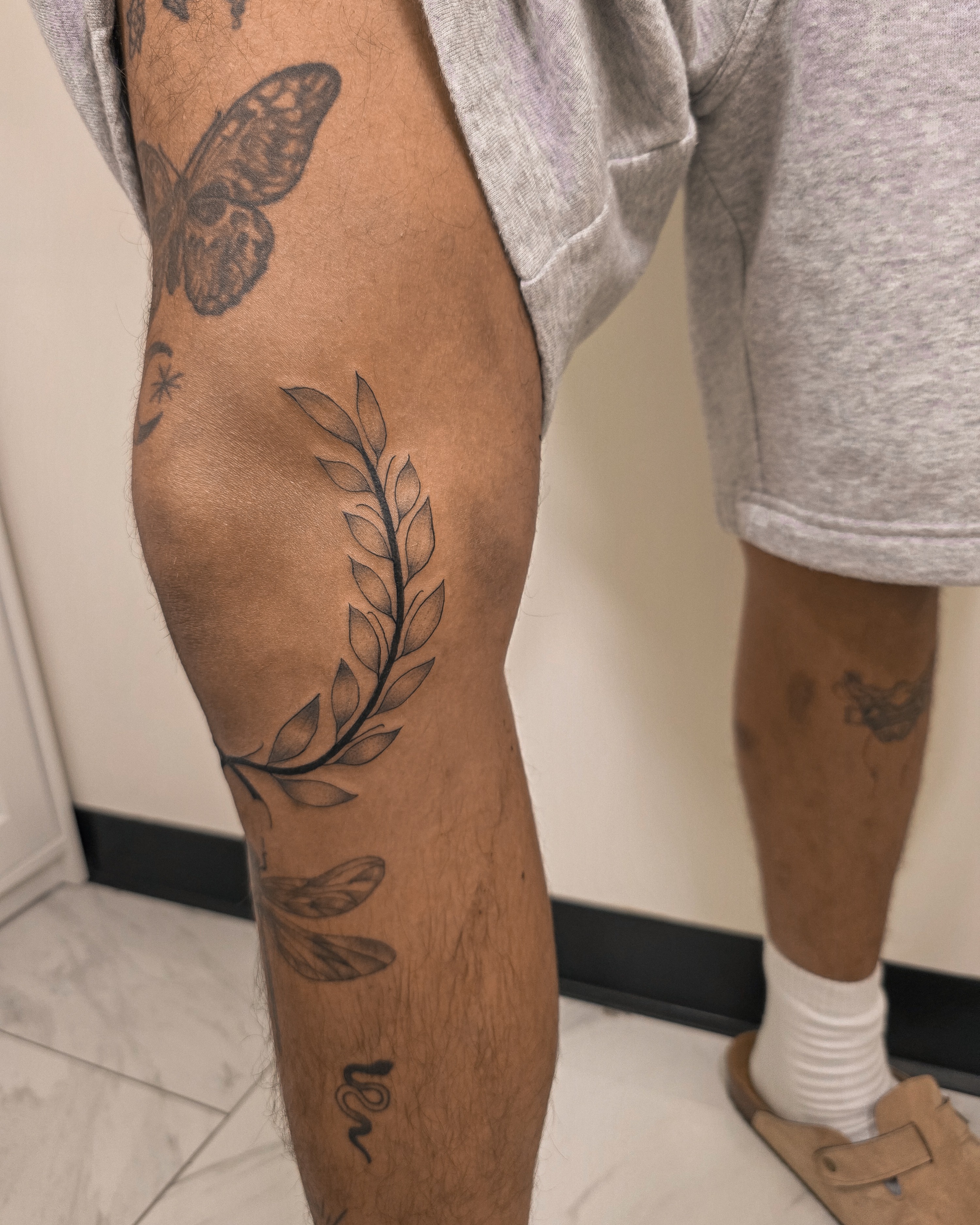 Wreath black and grey tattoo on the leg by Richmond tattoo shop, Richmond, Texas