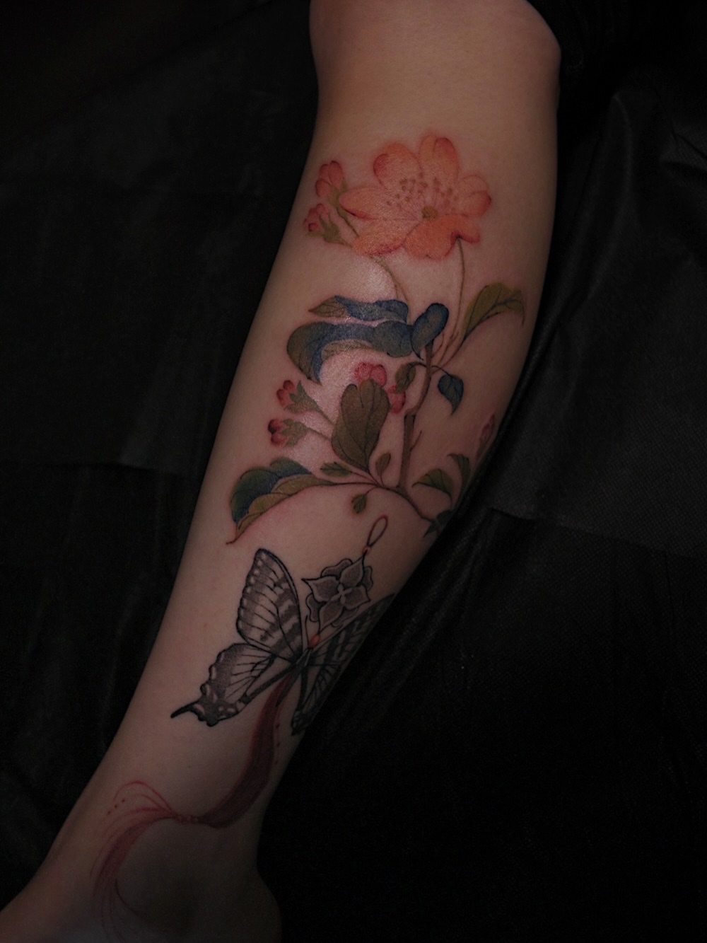 Floral and butterfly realism tattoo on the forearm by Temple Adorned Tattoo