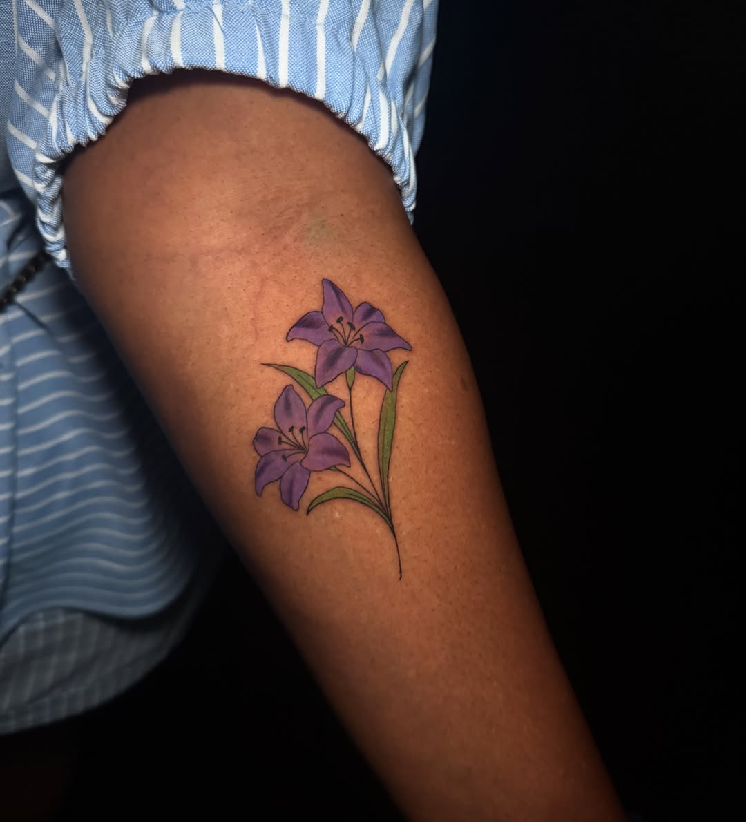 Purple lilies realism tattoo on the forearm by Lauren B