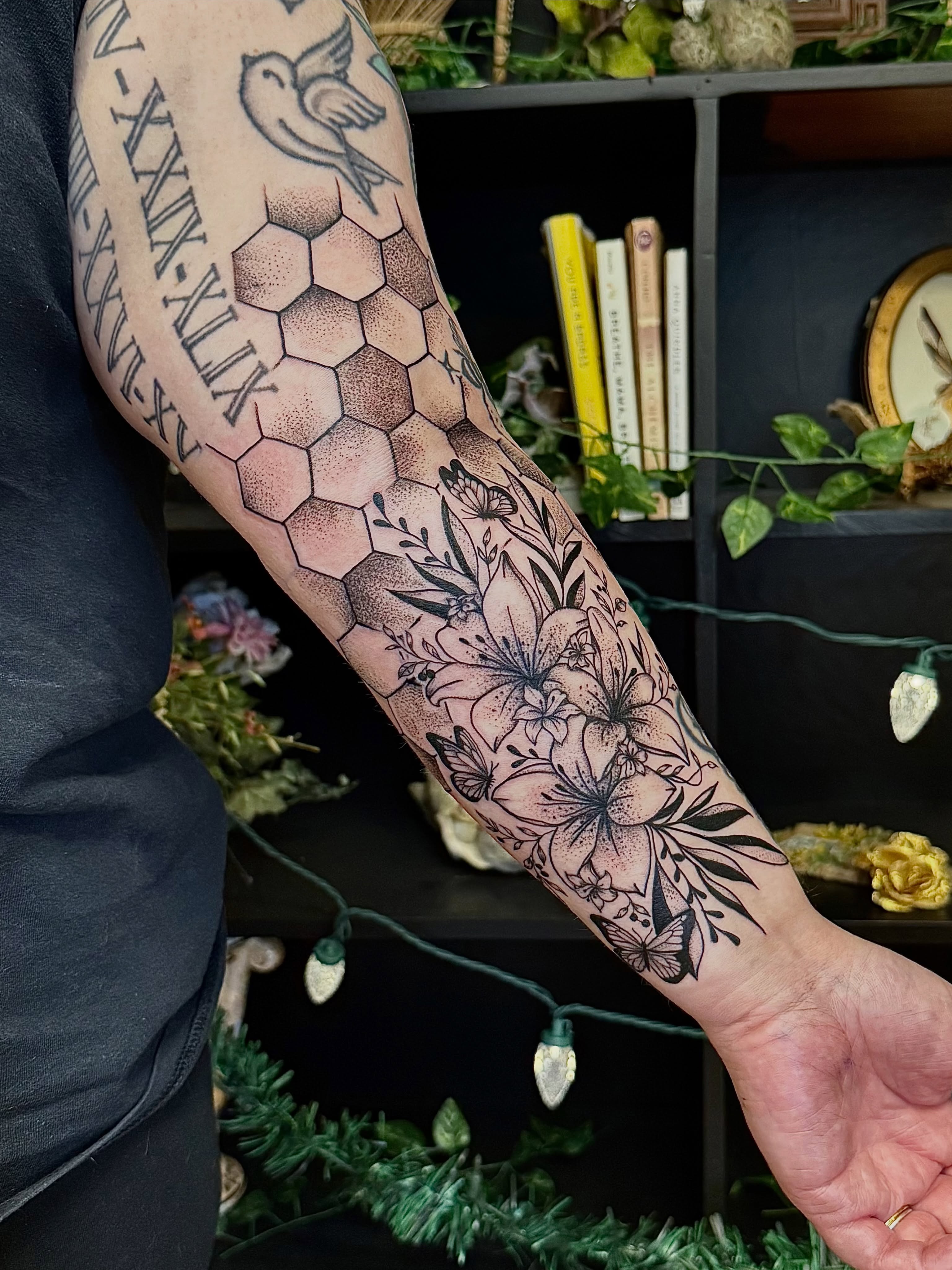 Floral hexagon dotwork tattoo on the forearm by Haley Bates
