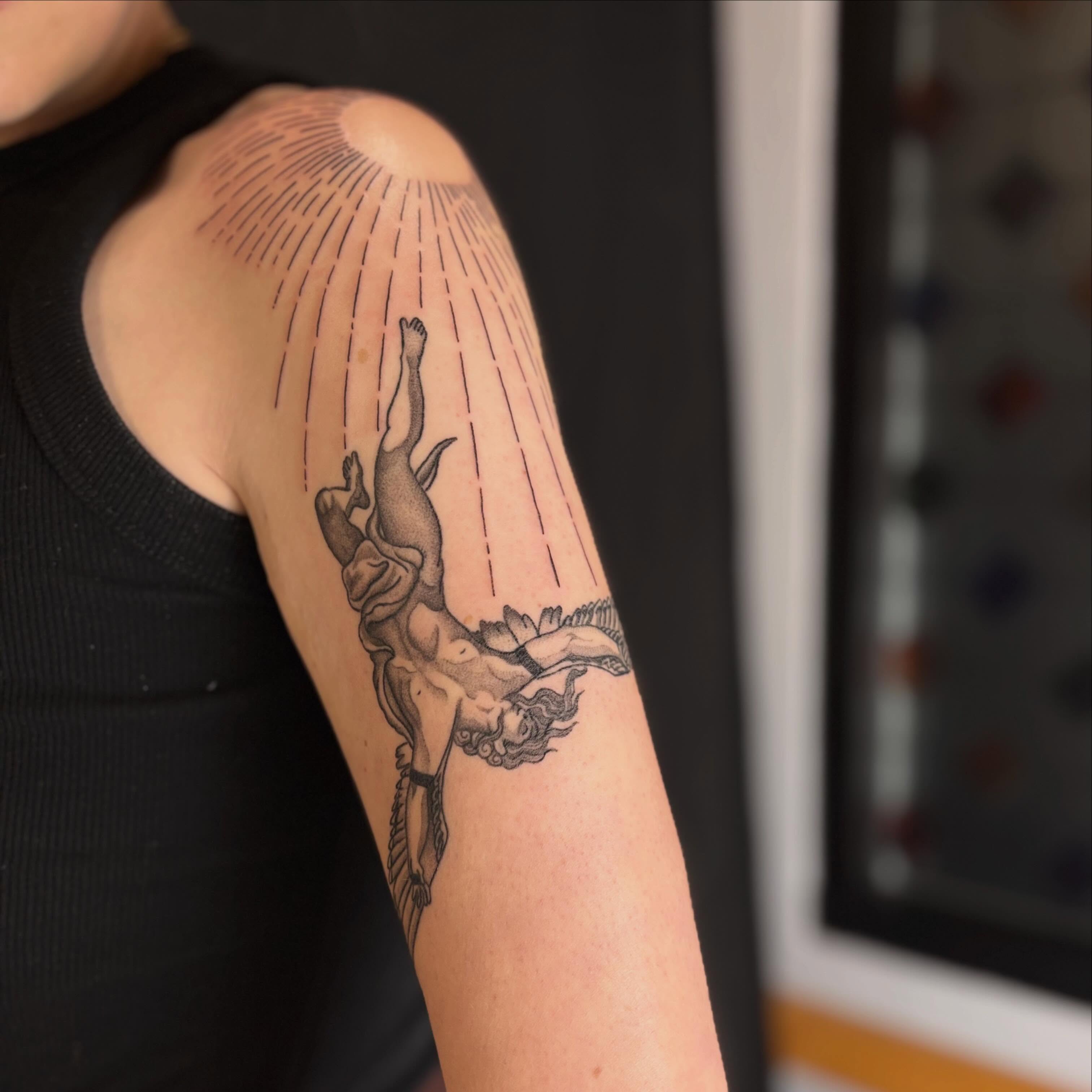 Mythological figure black and grey tattoo on the upper arm by Erica McCullough