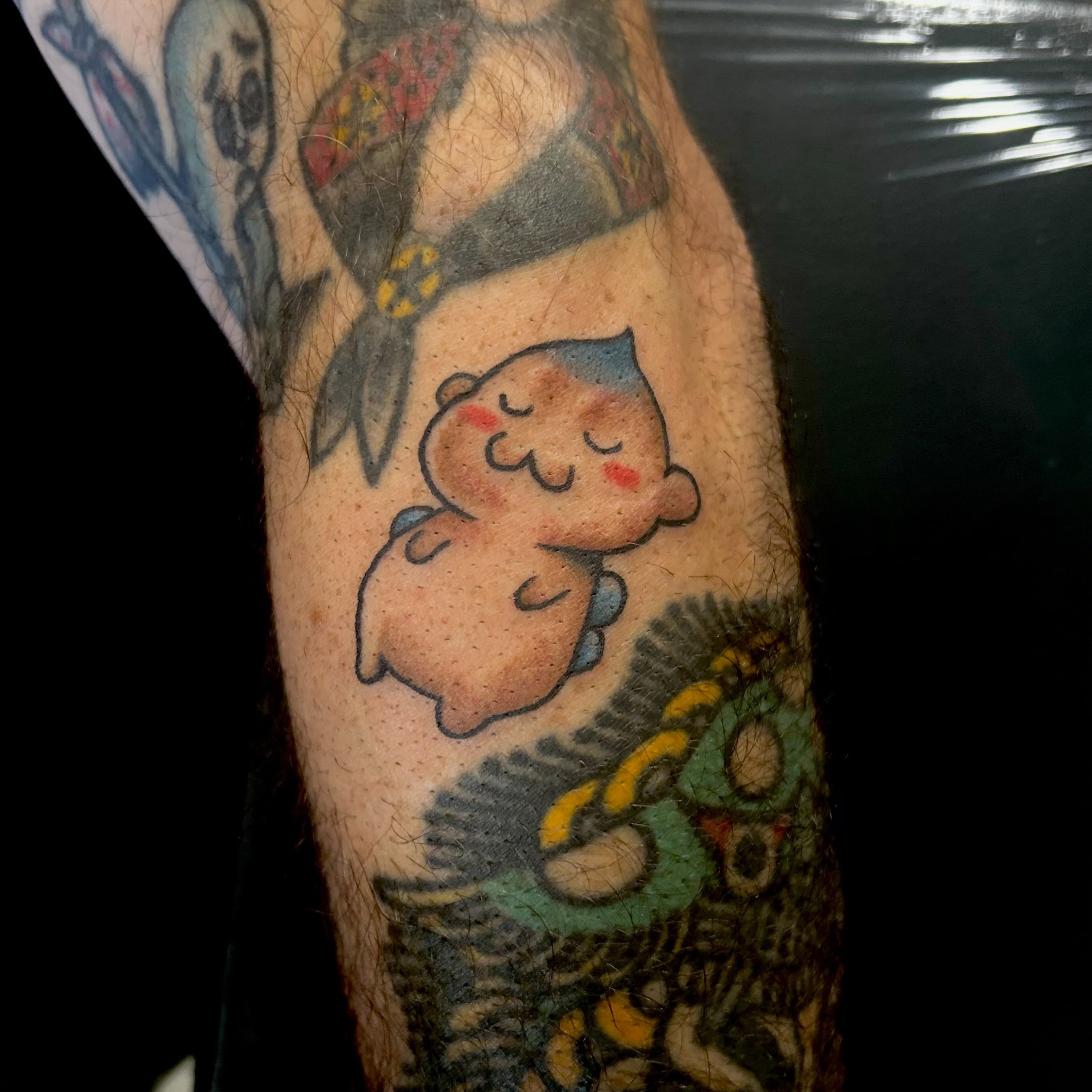 Kawaii character dotwork tattoo on the forearm by Tawni Bender