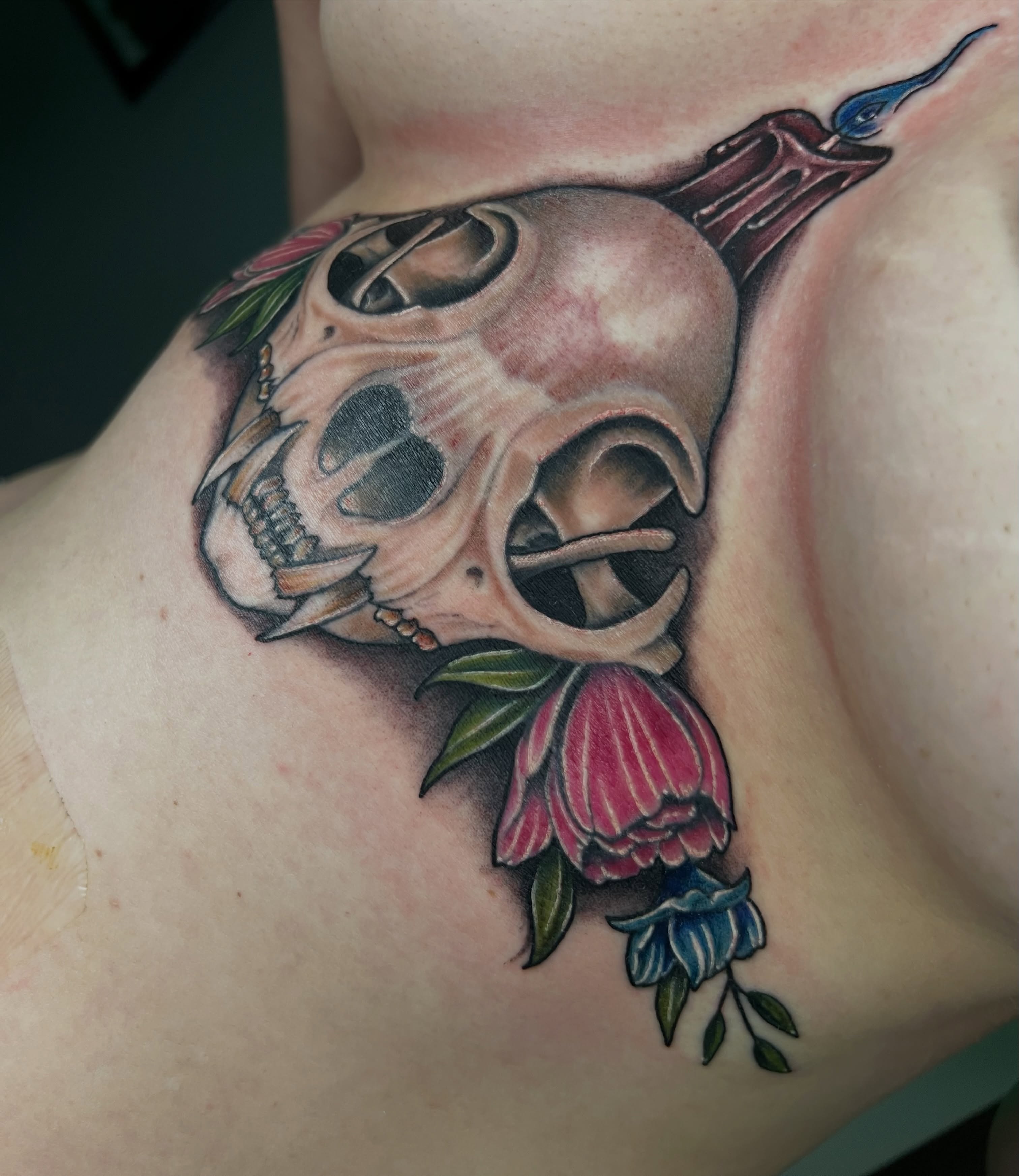 Skull and flower realism tattoo on the chest by Travis Sleeper